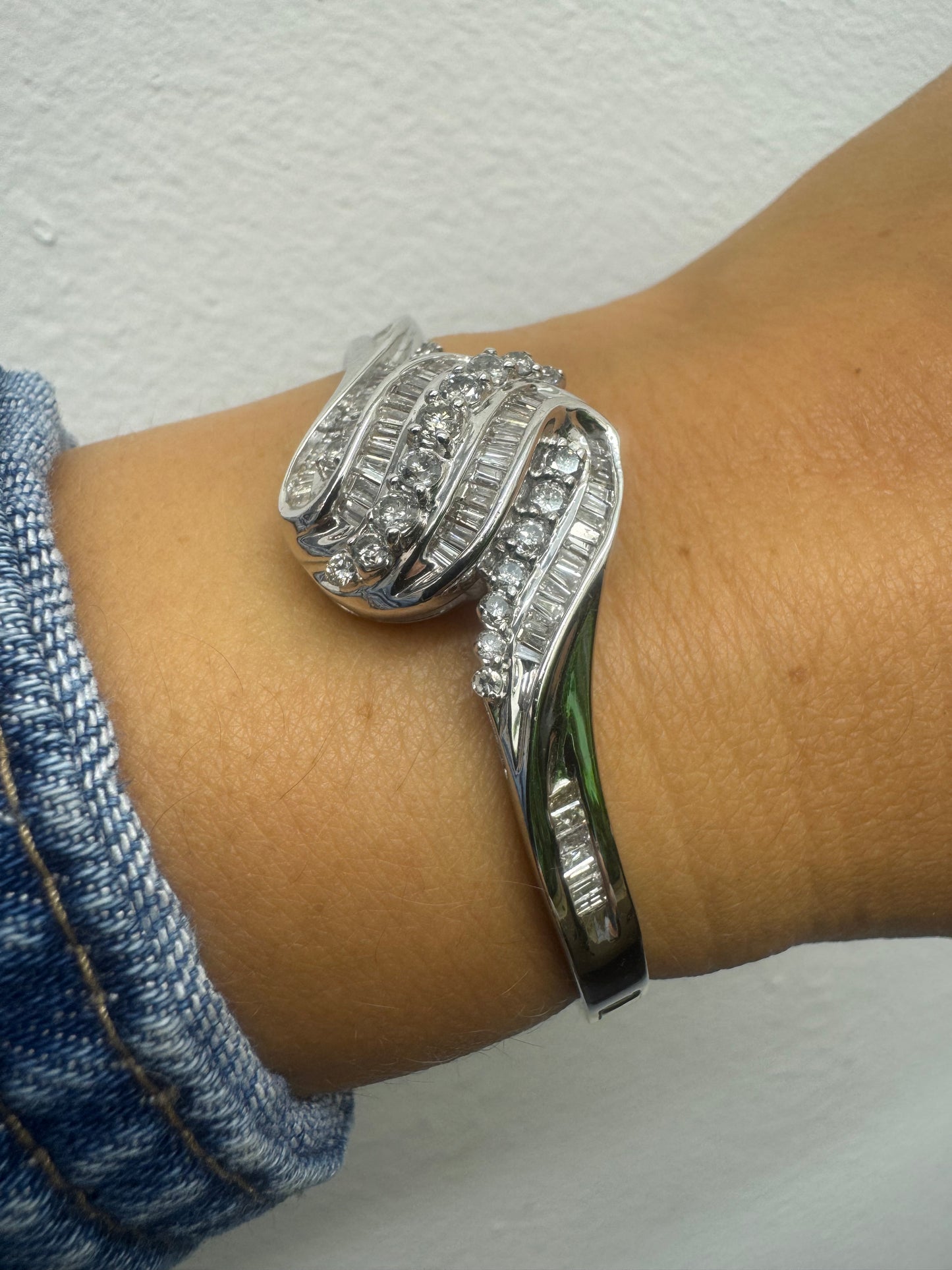 14K gold Hard bracelet featuring a flowing wave design, set with a dazzling mix of round and baguette-cut Diamonds