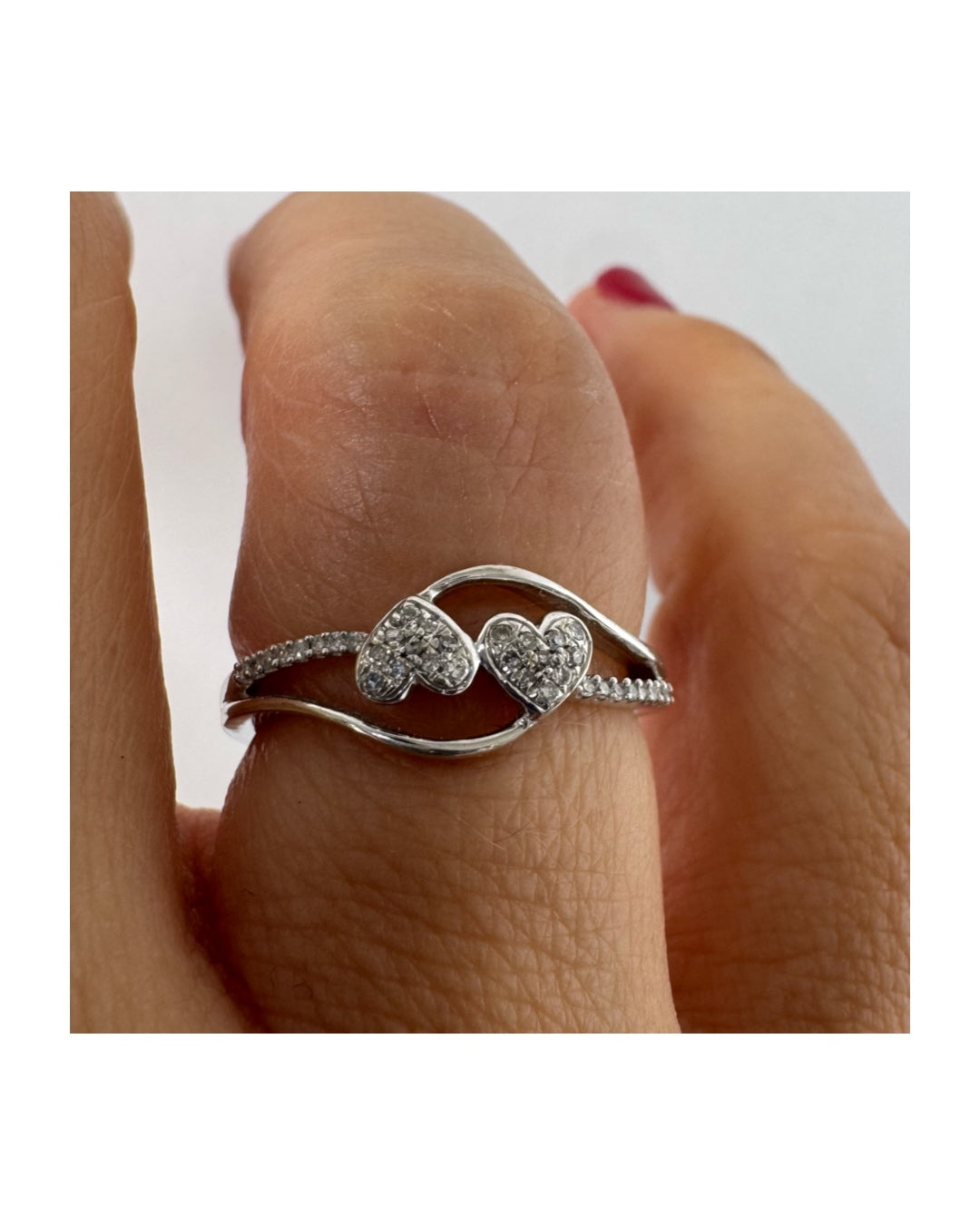 14K gold ring featuring a delicate and romantic design with two connected diamond hearts