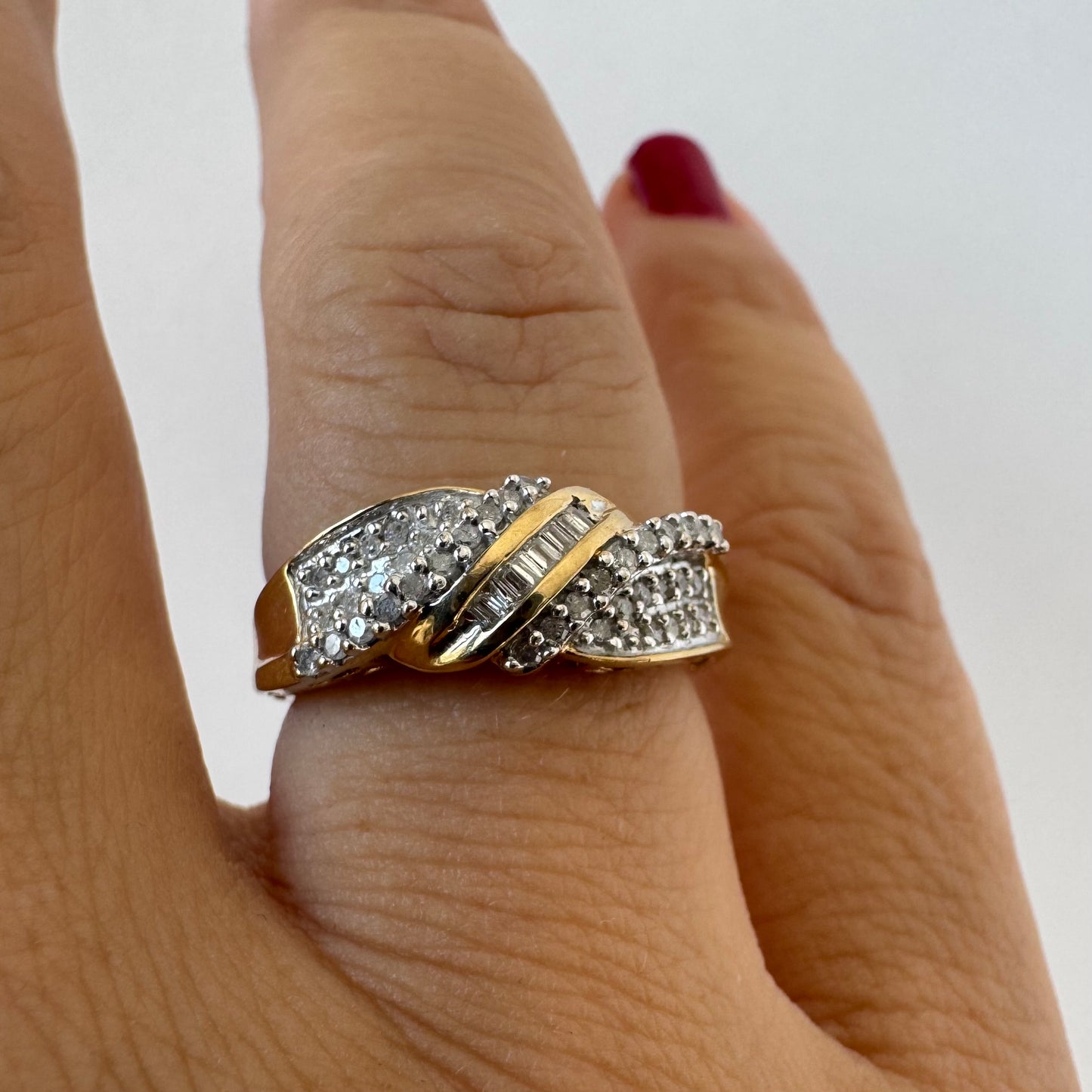 10K gold ring set with round-cut Diamonds and a central row of baguette Diamonds.