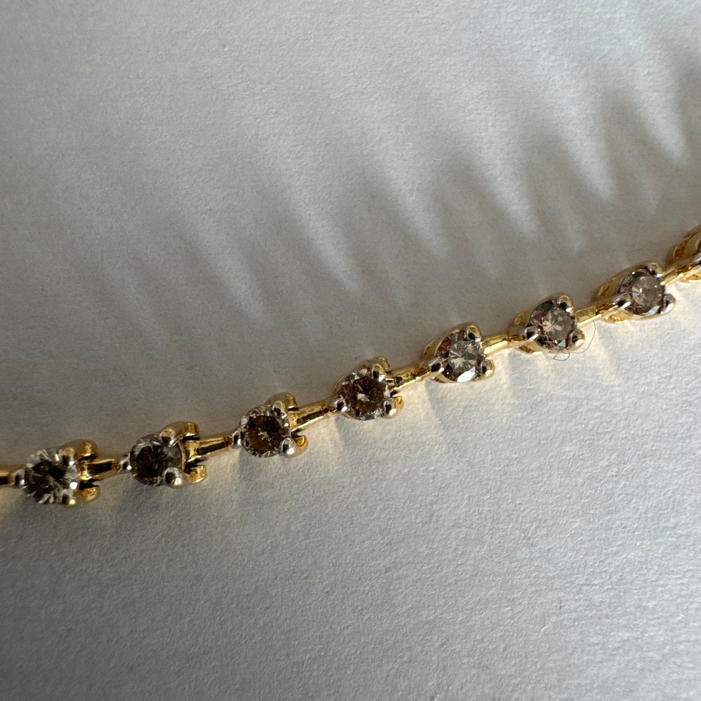 צמיד טניס מזהב צהוב 14 קראט משובץ שורת יהלומים, היוצרים ברק רציף ומראה נקי ועל-זמני.