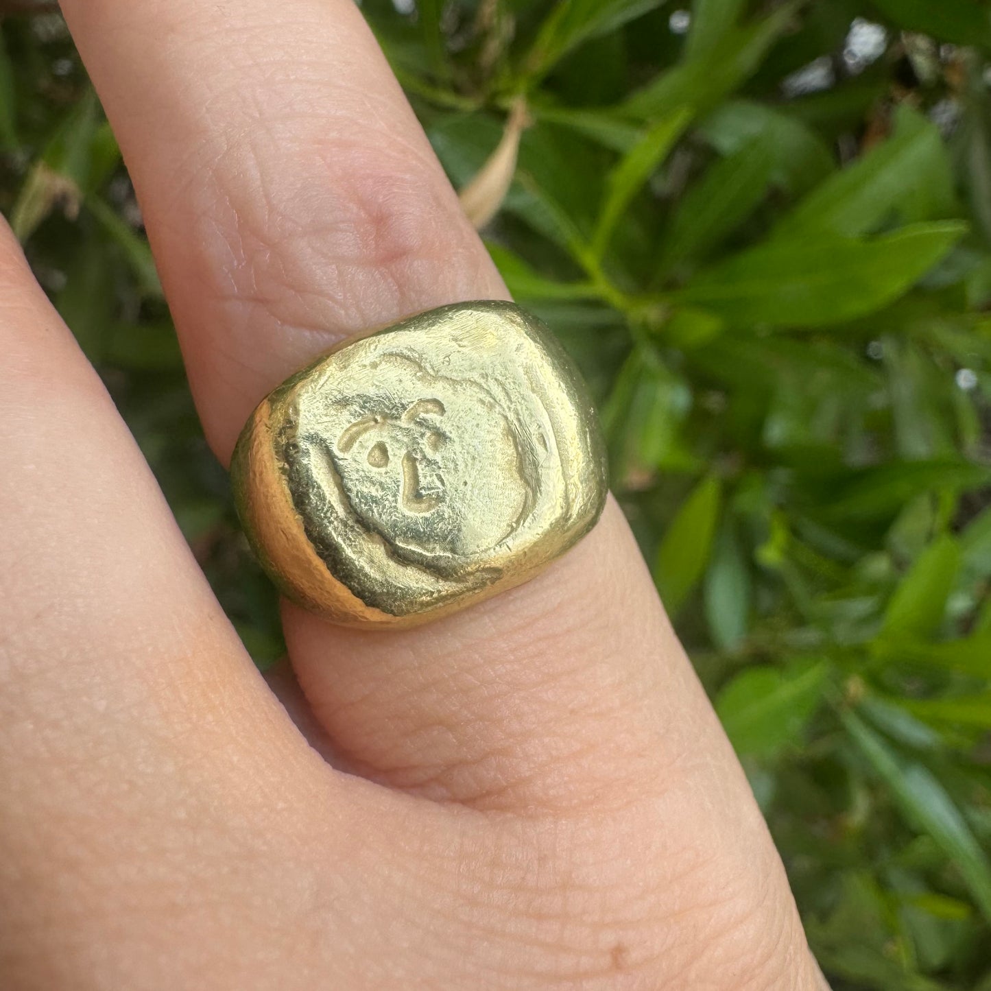 18K gold chunky gold ring with a rustic, organic finish, featuring an engraved abstract face motif at its center.