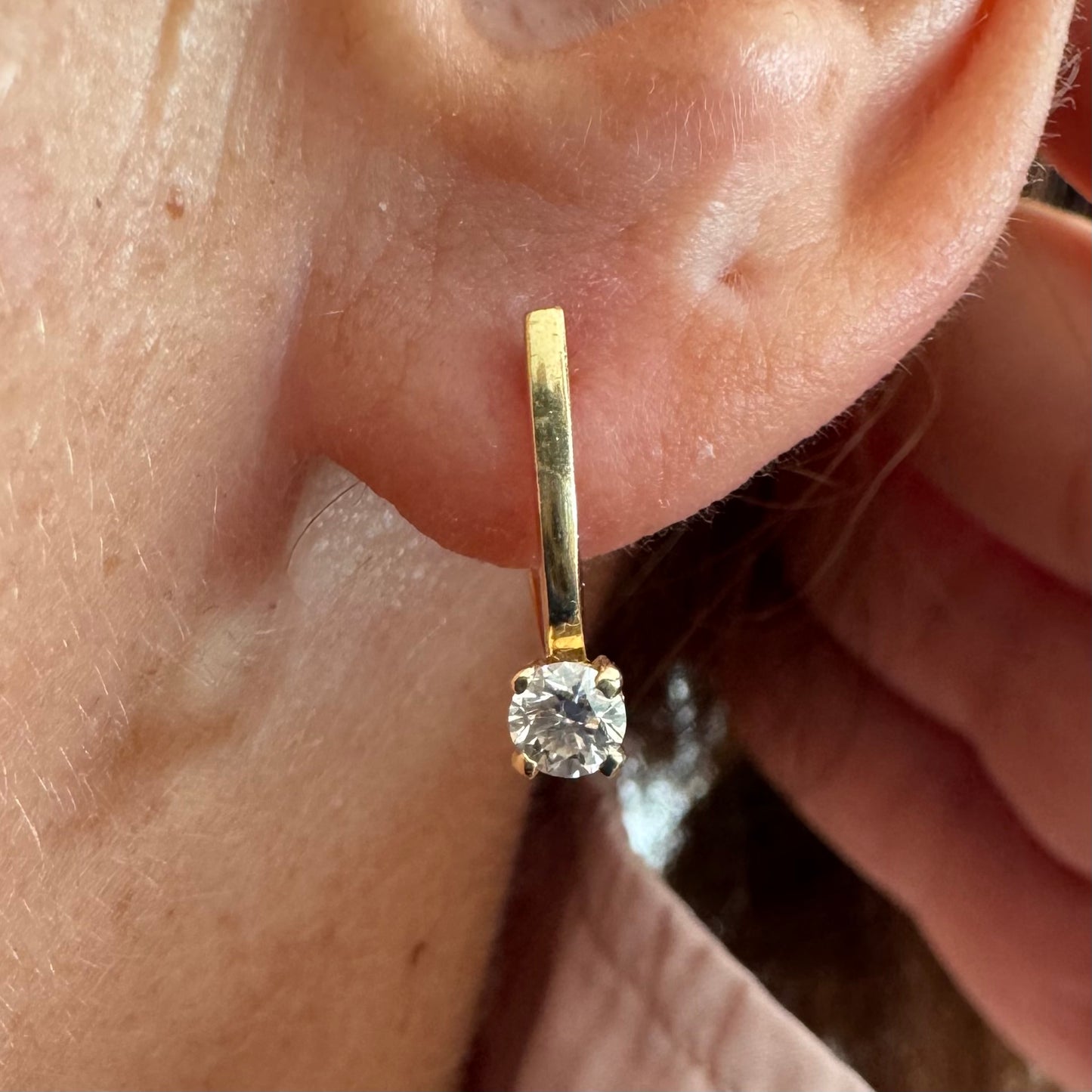 14K gold earrings set with round brilliant-cut Diamonds.