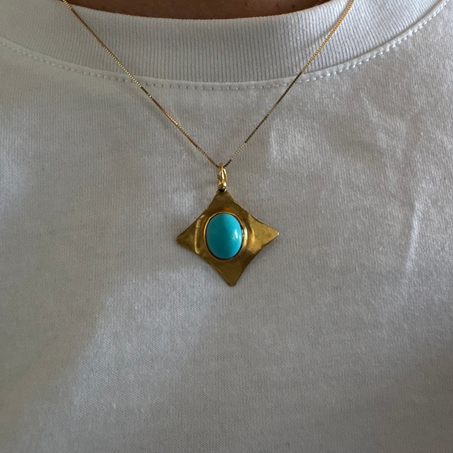 18K gold pendant set with a vibrant Turquoise stone in a bold, geometric design.