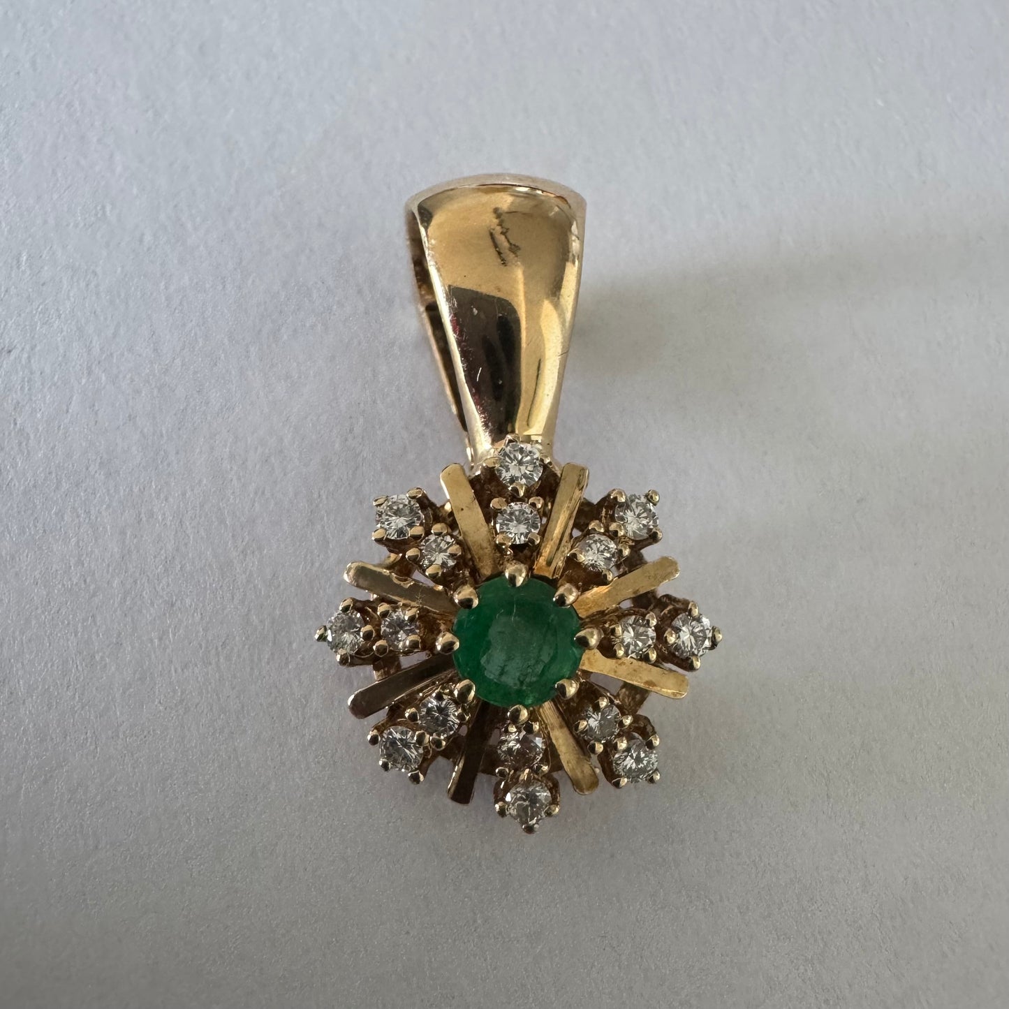 14K gold pendant centered with a Emerald and surrounded by a halo of sparkling Diamonds