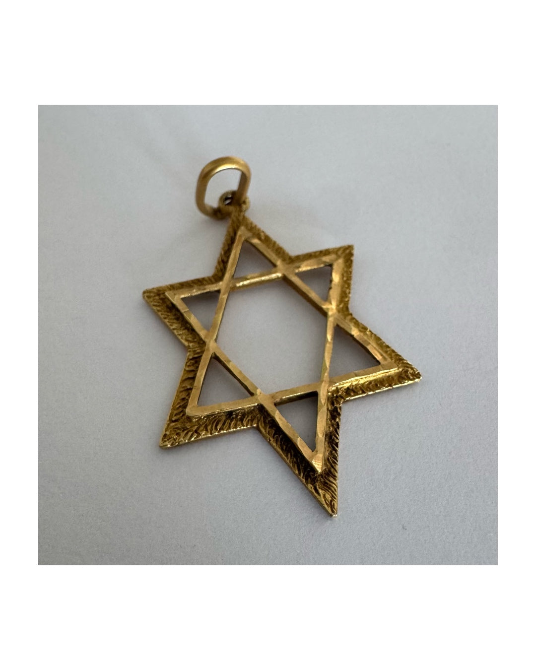 14K gold Star of David pendant with textured detailing and an open design.