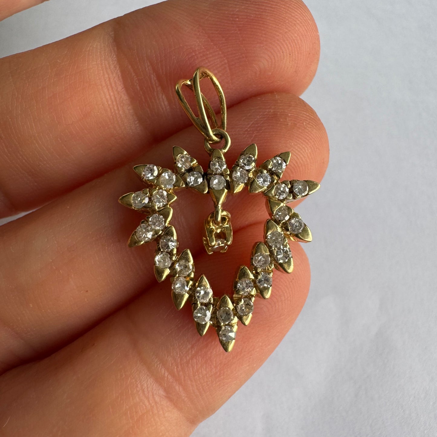 תליון זהב צהוב 14 קראט בצורת לב, משובץ יהלומים בסידור עדין היוצר מראה עשיר ומלא ברק.