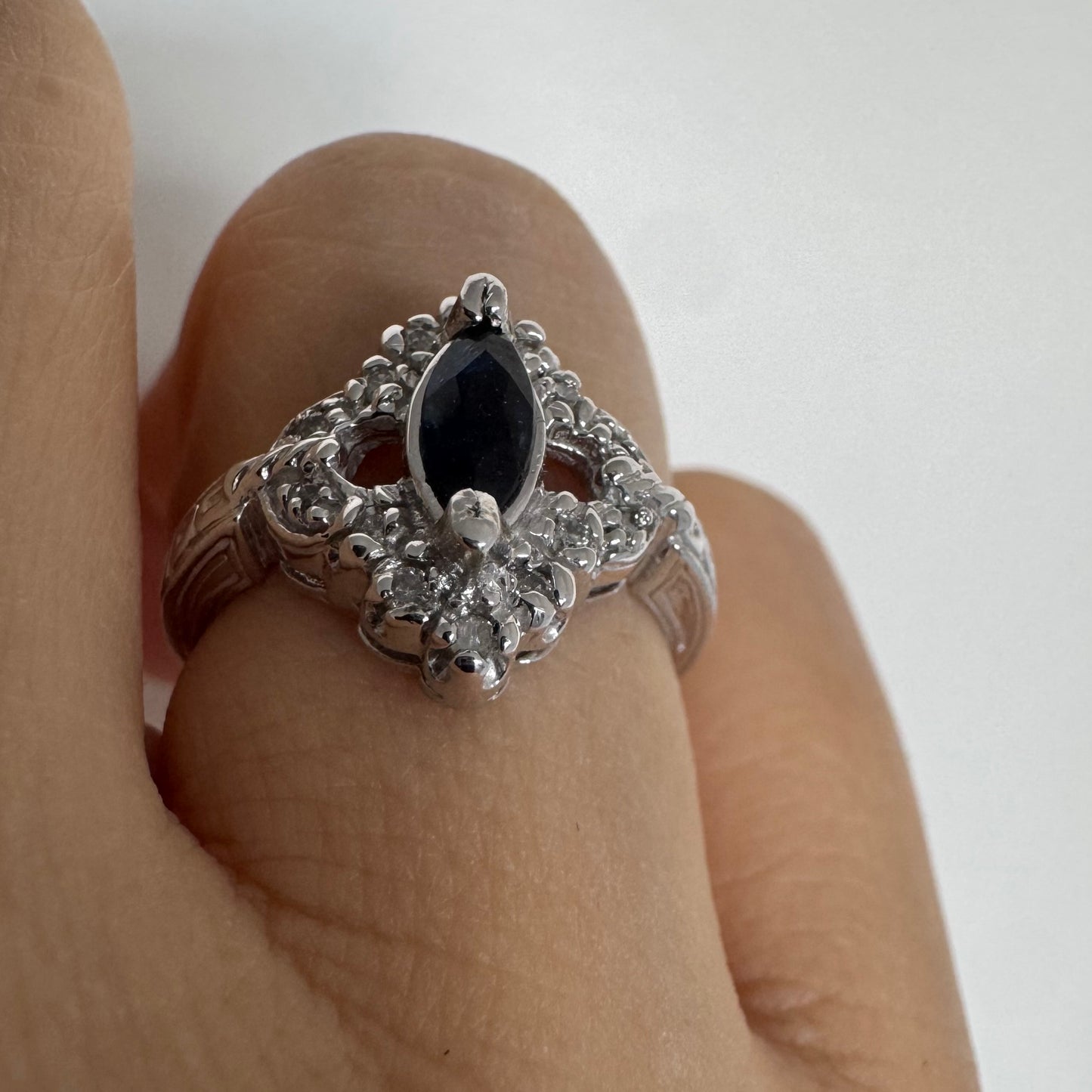 טבעת זהב לבן 14 קראט משובצת אבן ספיר בצבע כחול כהה בחיתוך מרקיזה ומסביב משובצים יהלומים