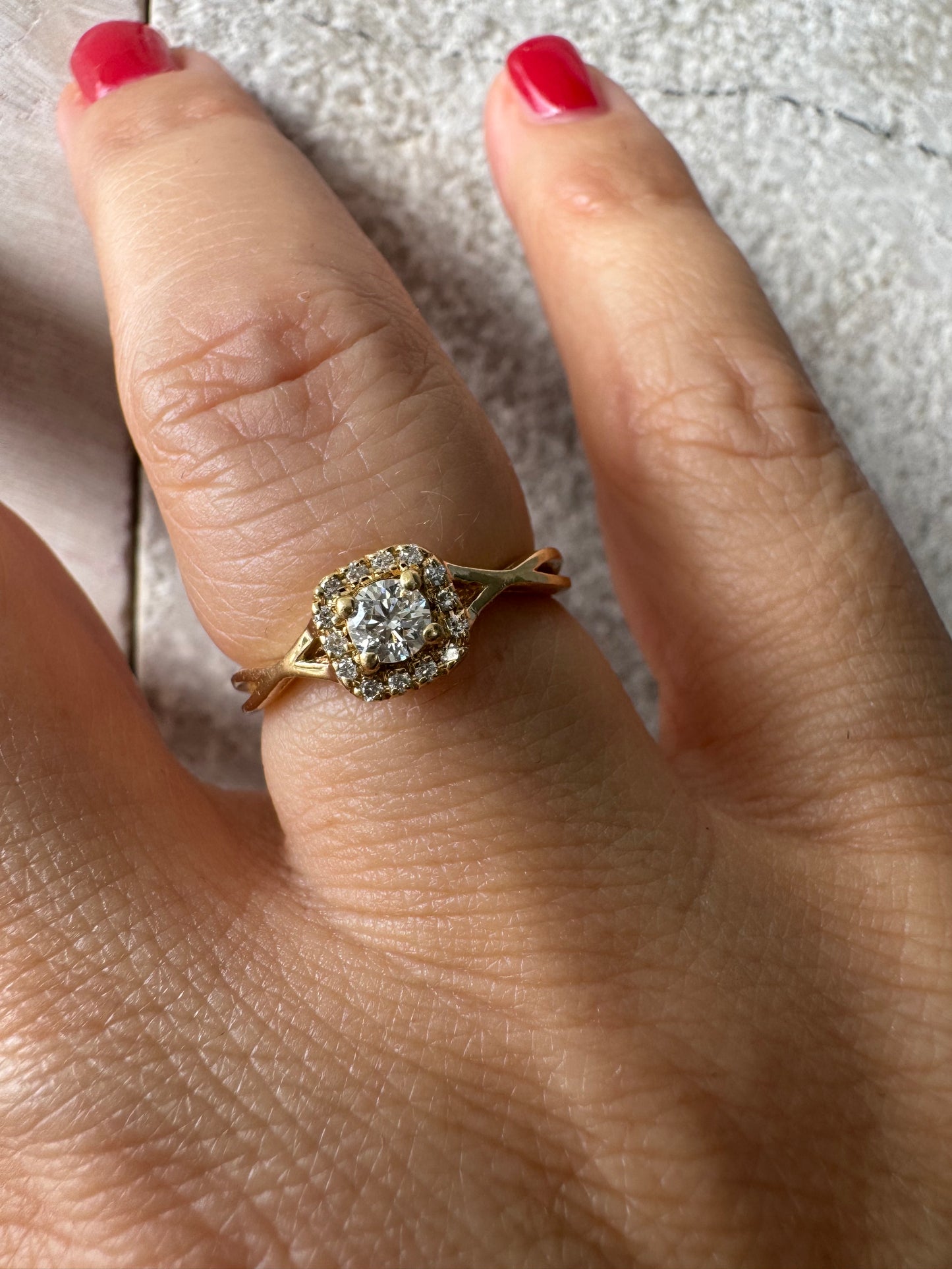14K gold ring set with a central Diamond surrounded by small Diamonds