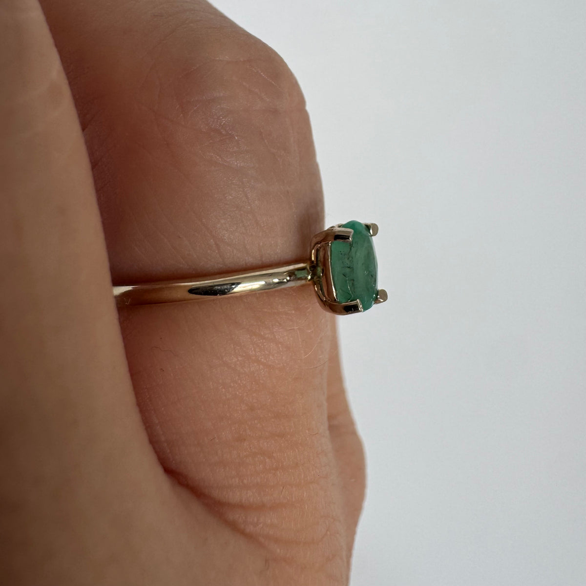 14K gold ring set with an oval-cut Emerald