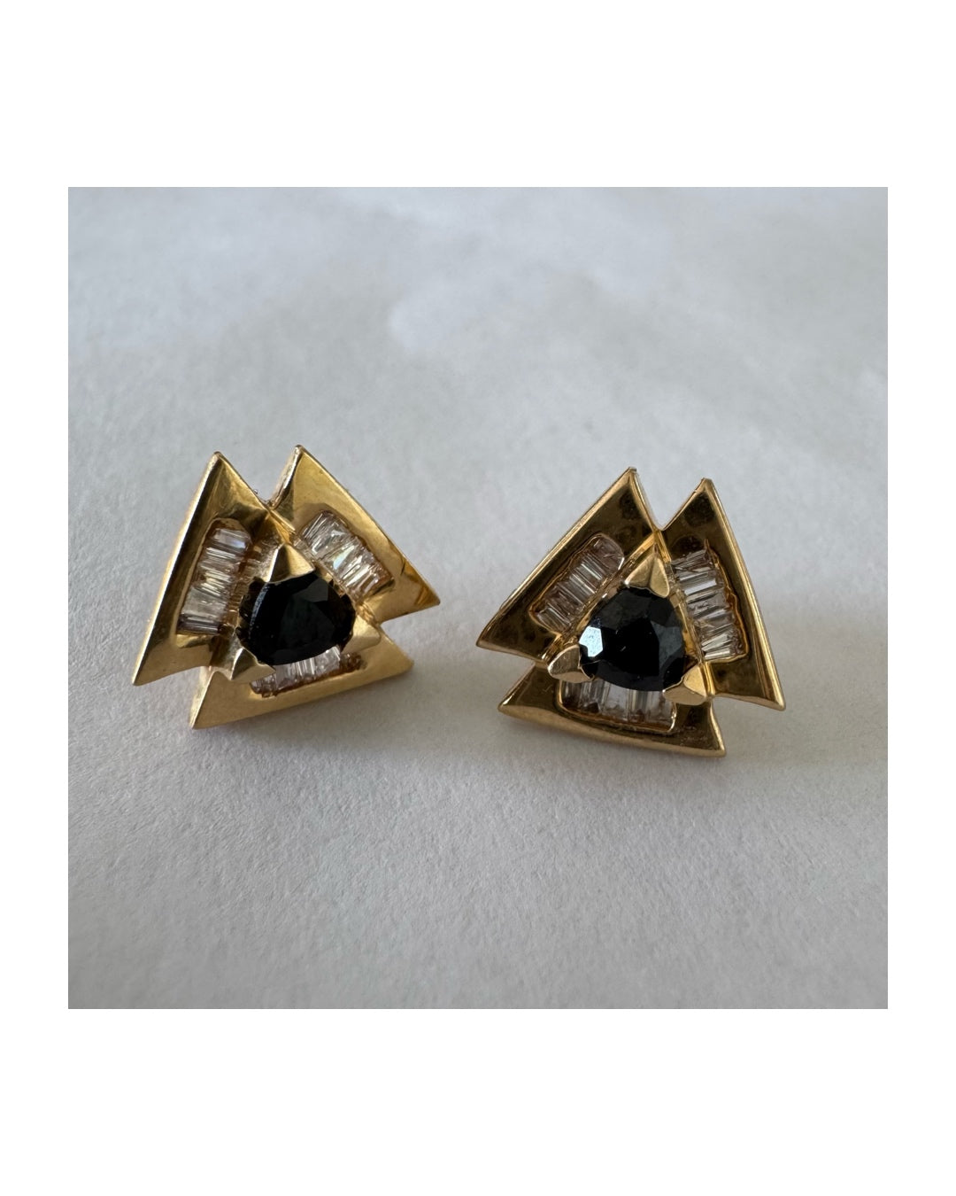 14K gold geometric stud earrings set with a Sapphire stone, surrounded by baguette Diamonds.