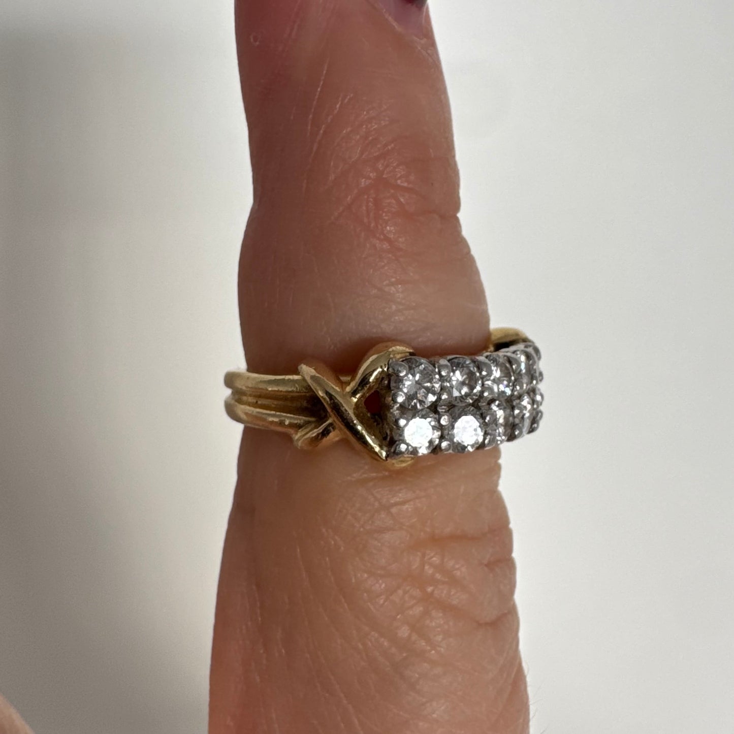 טבעת זהב צהוב 18 קראט משובצת יהלומים עגולים בשתי שורות צפופות, במבנה מלבני מעוגל.