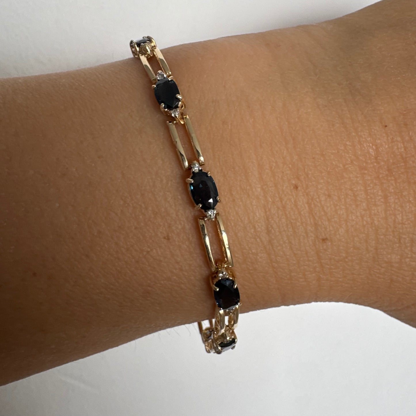 צמיד זהב צהוב 14 קראט משובץ אבני טופז כחולות בחיתוך אובלי, עם יהלומים המשובצים ביניהן להוספת ברק עדין.