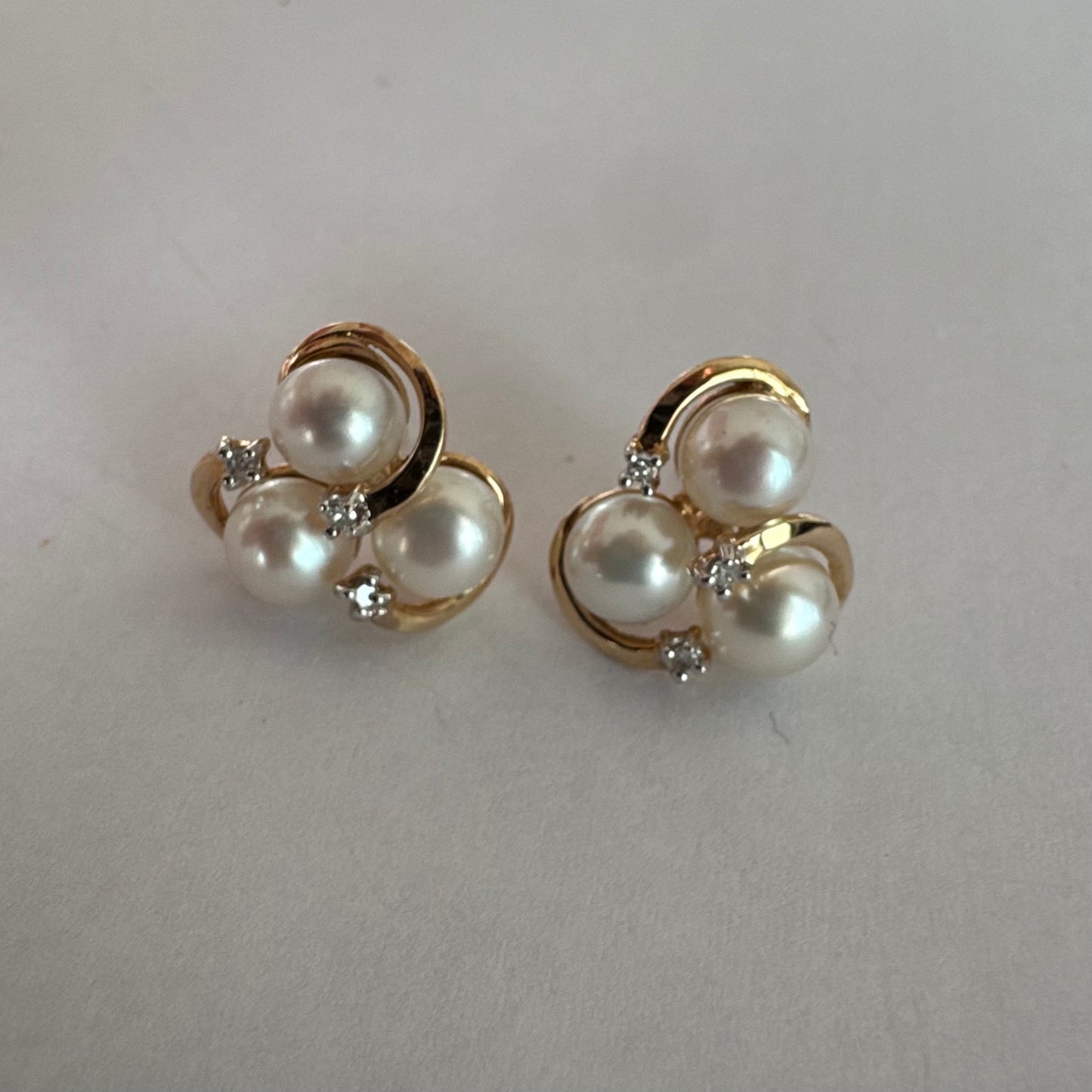 10K gold stud earrings in a delicate floral design, set with three creamy natural Pearls & Diamonds.
