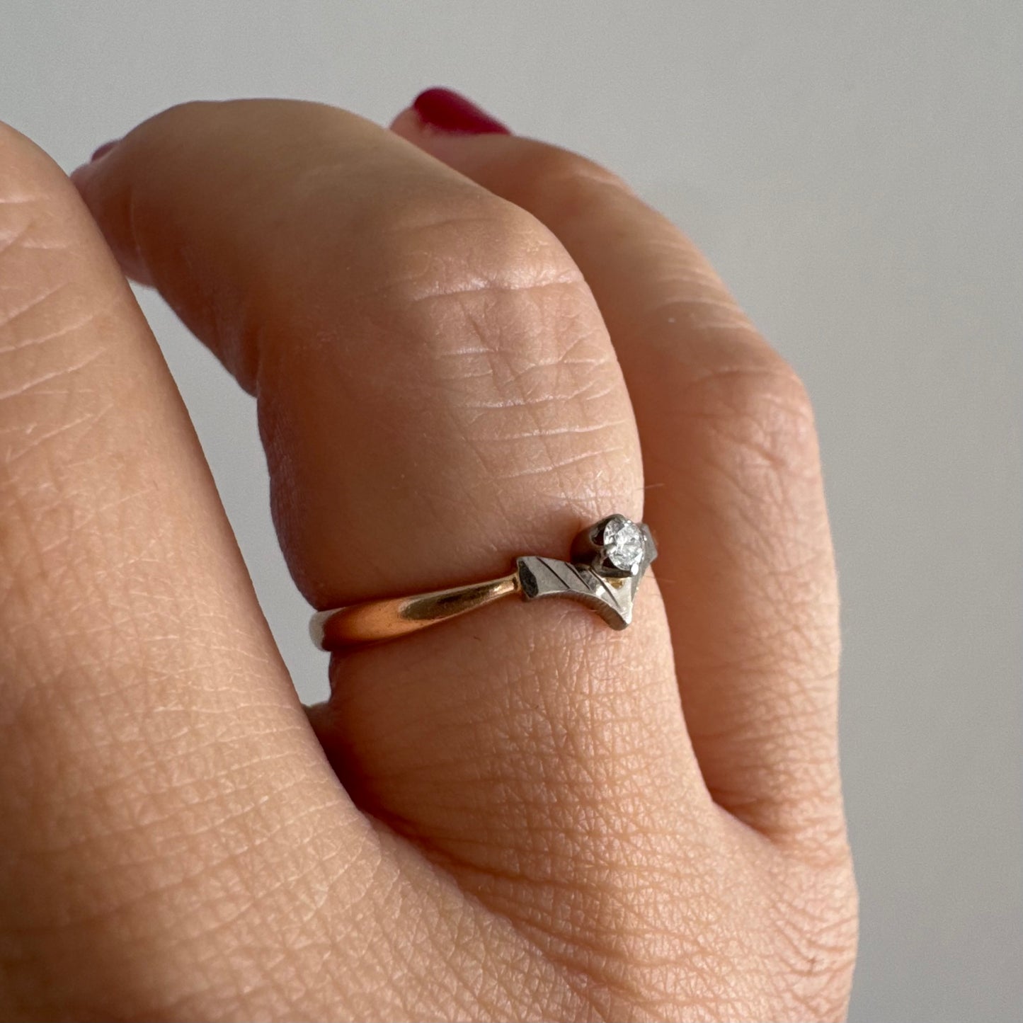 טבעת זהב 14 קראט עם ראש בצורת V מזהב לבן המשובץ יהלום עגול אחד. 