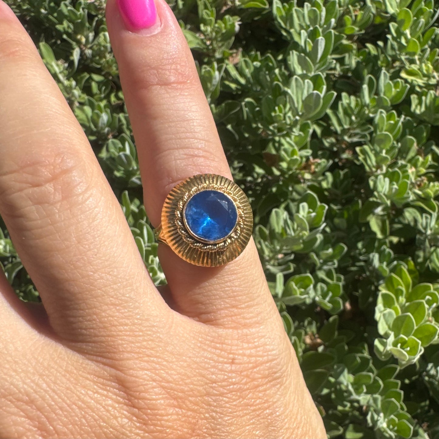 18K gold ring featuring a vibrant round Blue Topaz set in a textured gold bezel.