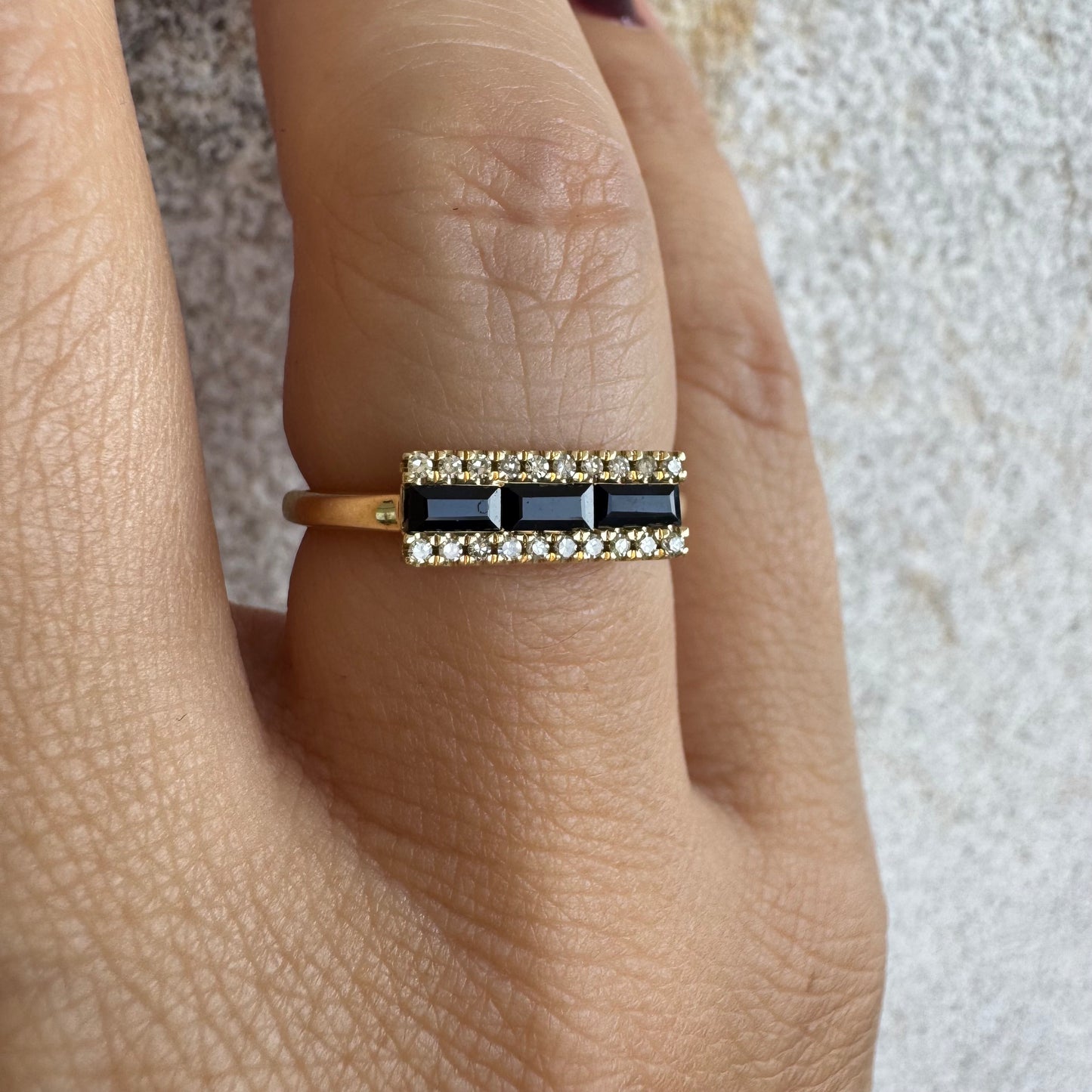 14K gold ring set with baguette-cut Sapphire framed by sparkling Diamonds