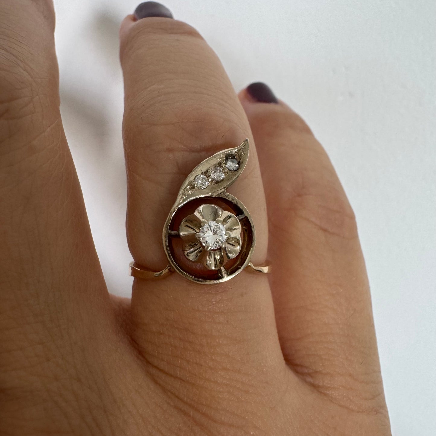 טבעת זהב צהוב 14 קראט בעיצוב פרח עדין המשובצת יהלומים נוצצים .
