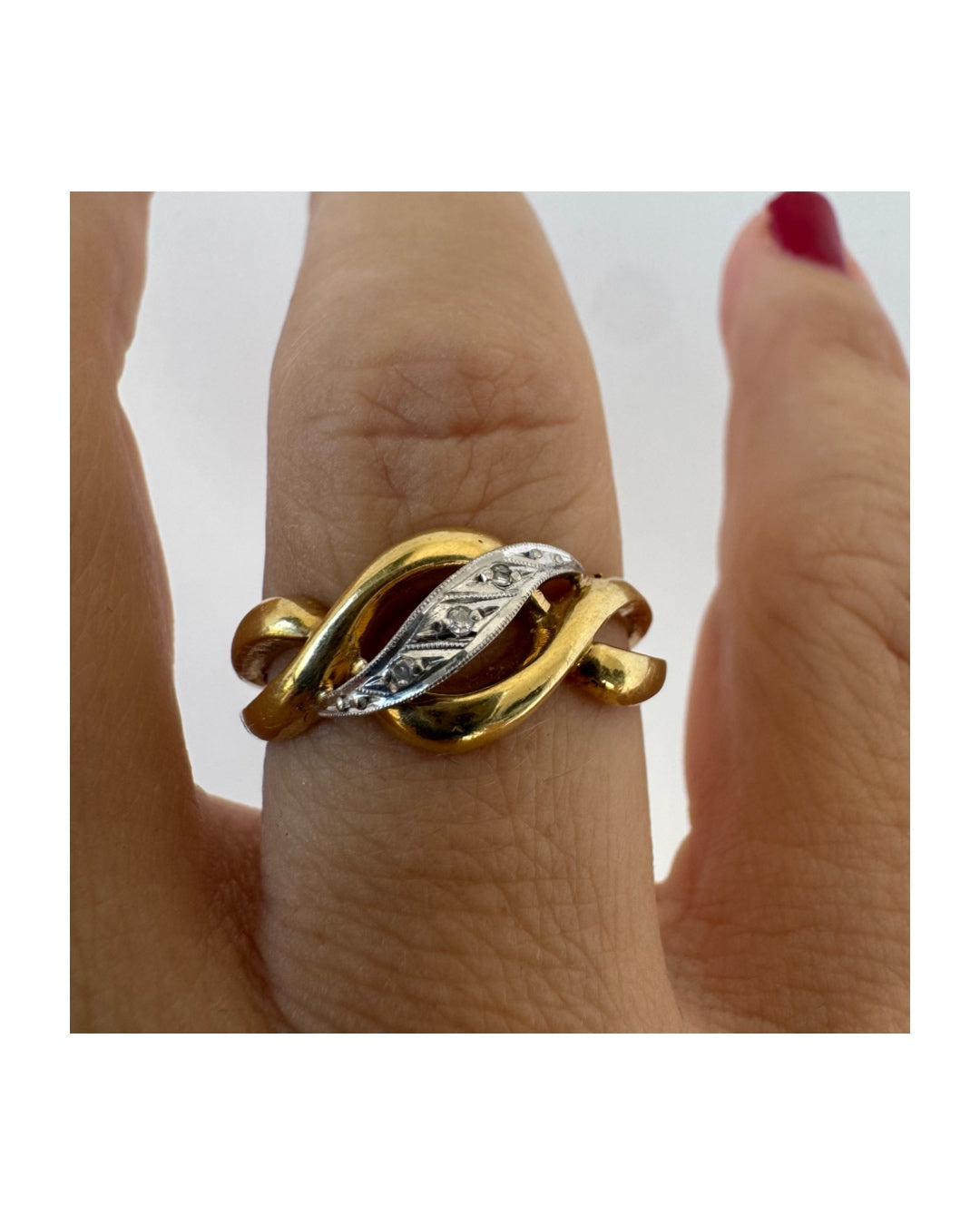 18K gold knot-style ring featuring a white gold center accented with delicate Diamonds.