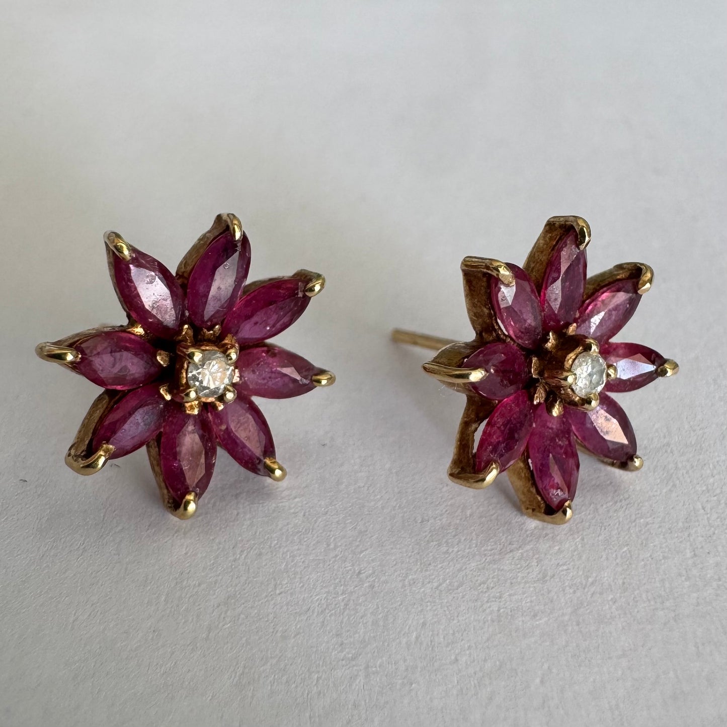 14K gold floral earrings set with marquise-cut Rubies and a small Diamond at the center
