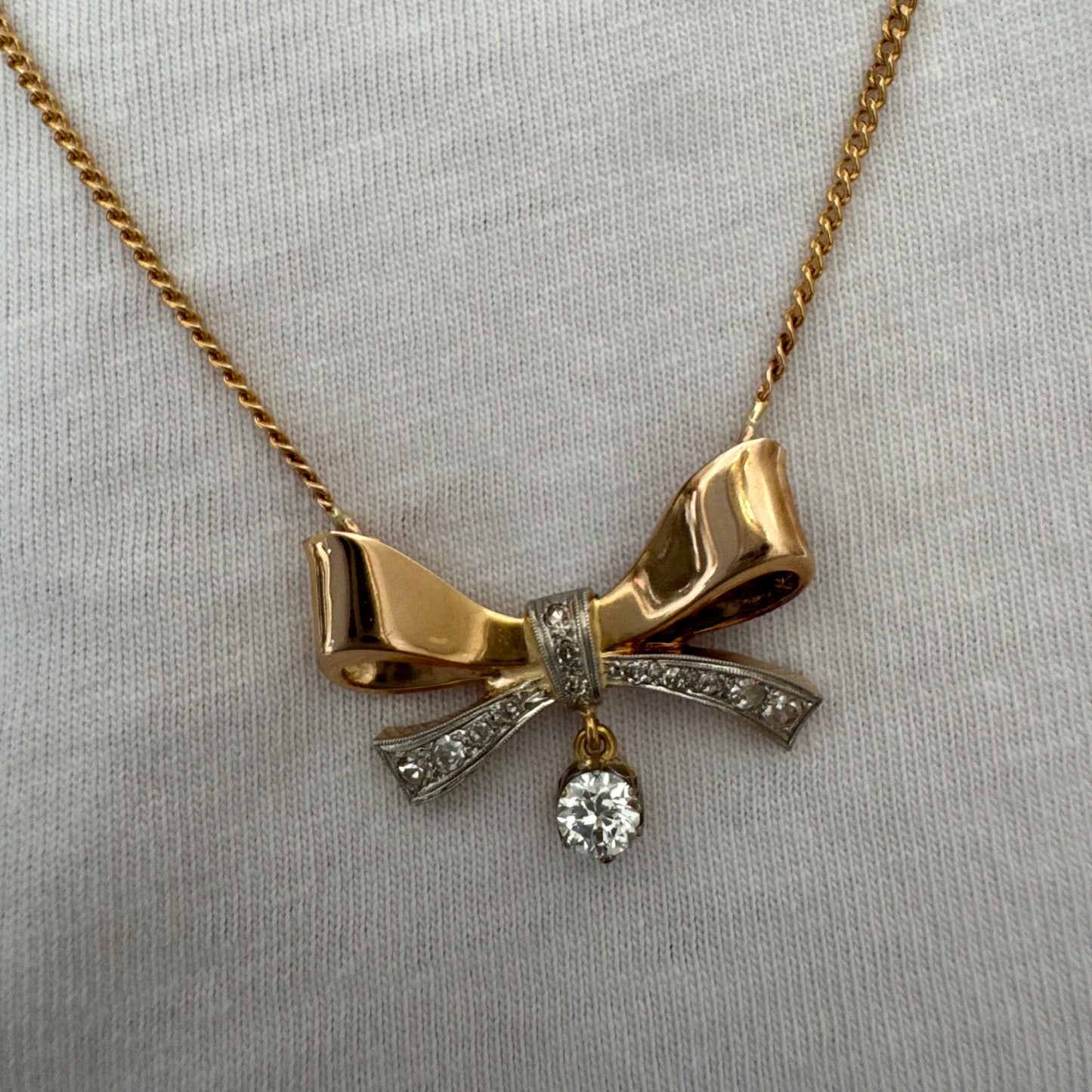 שרשרת זהב 18 קראט עם תליון בצורת סרט קלאסי משובץ יהלומים ונושא יהלום מרכזי תלוי שמוסיף נגיעה של זוהר ואלגנטיות