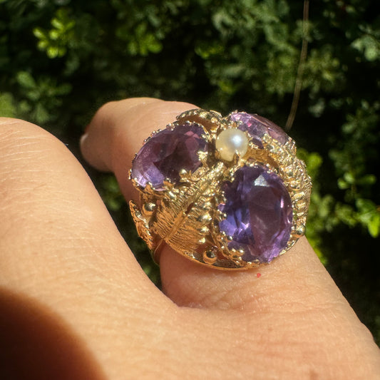 14K gold ring set with four glowing Amethyst stones encircling a delicate central Pearl.