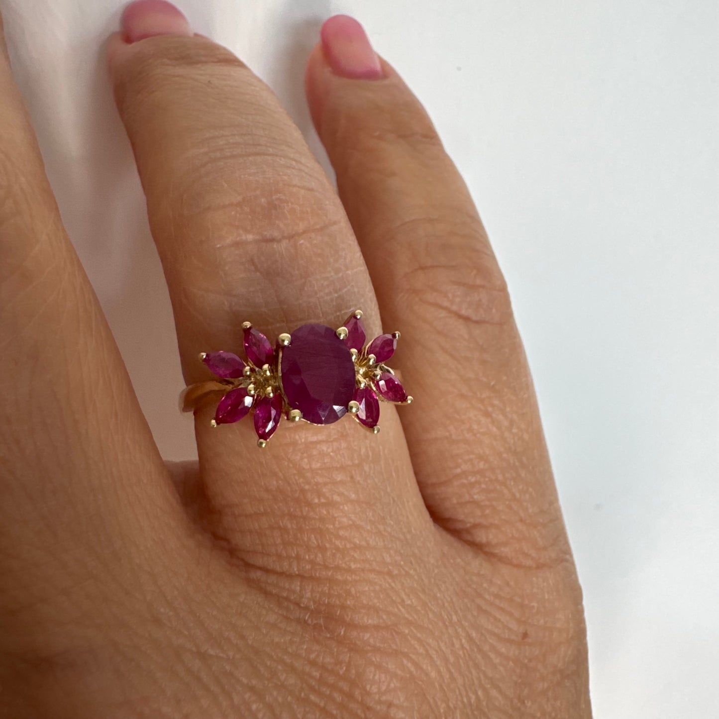 טבעת זהב צהוב 14 קראט משובצת רובי מרכזי גדול ולצידו רובי בחיתוך מרקיזה בעיצוב פרחוני עשיר.