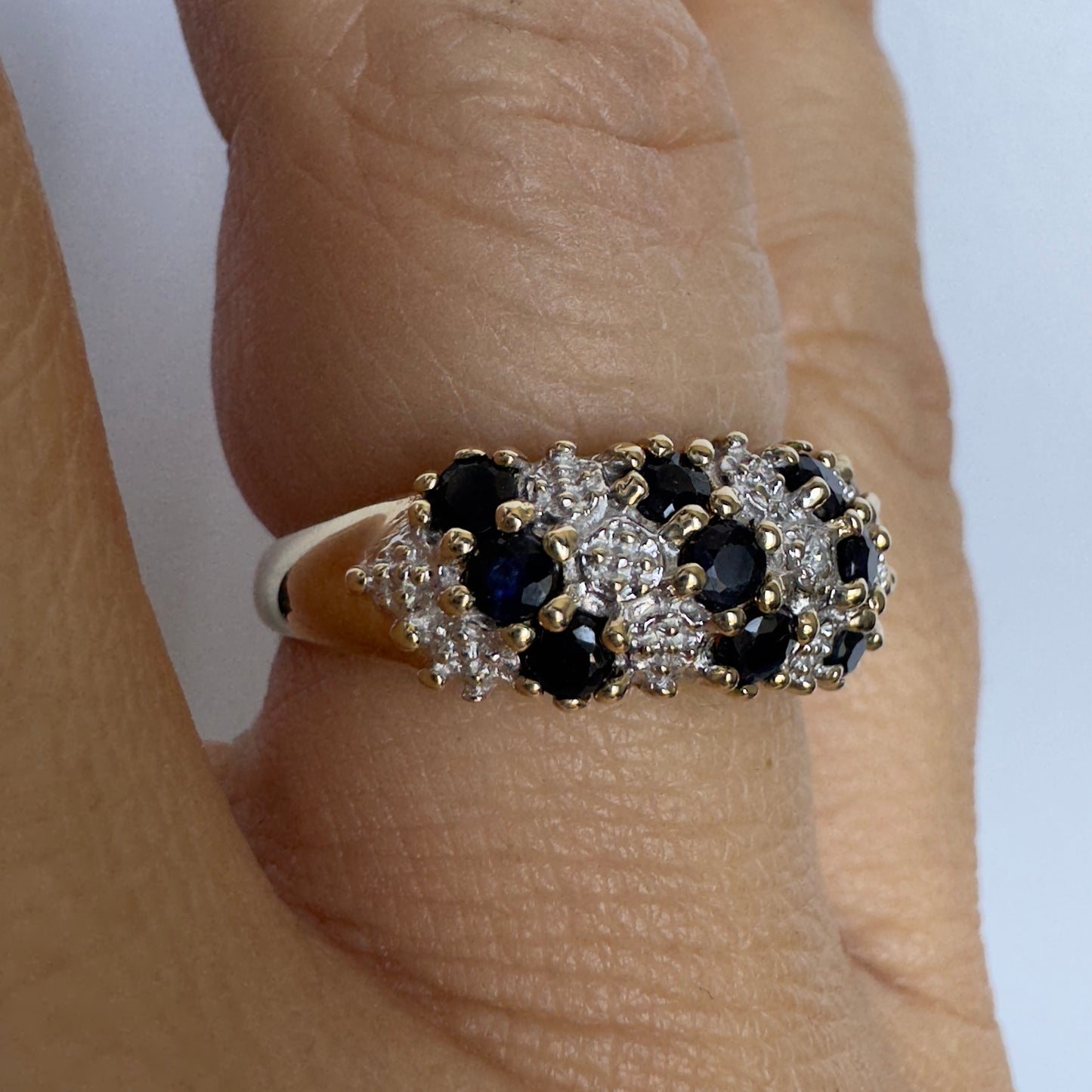 10K gold ring set with deep blue Sapphires and Diamonds in a classic, romantic design.