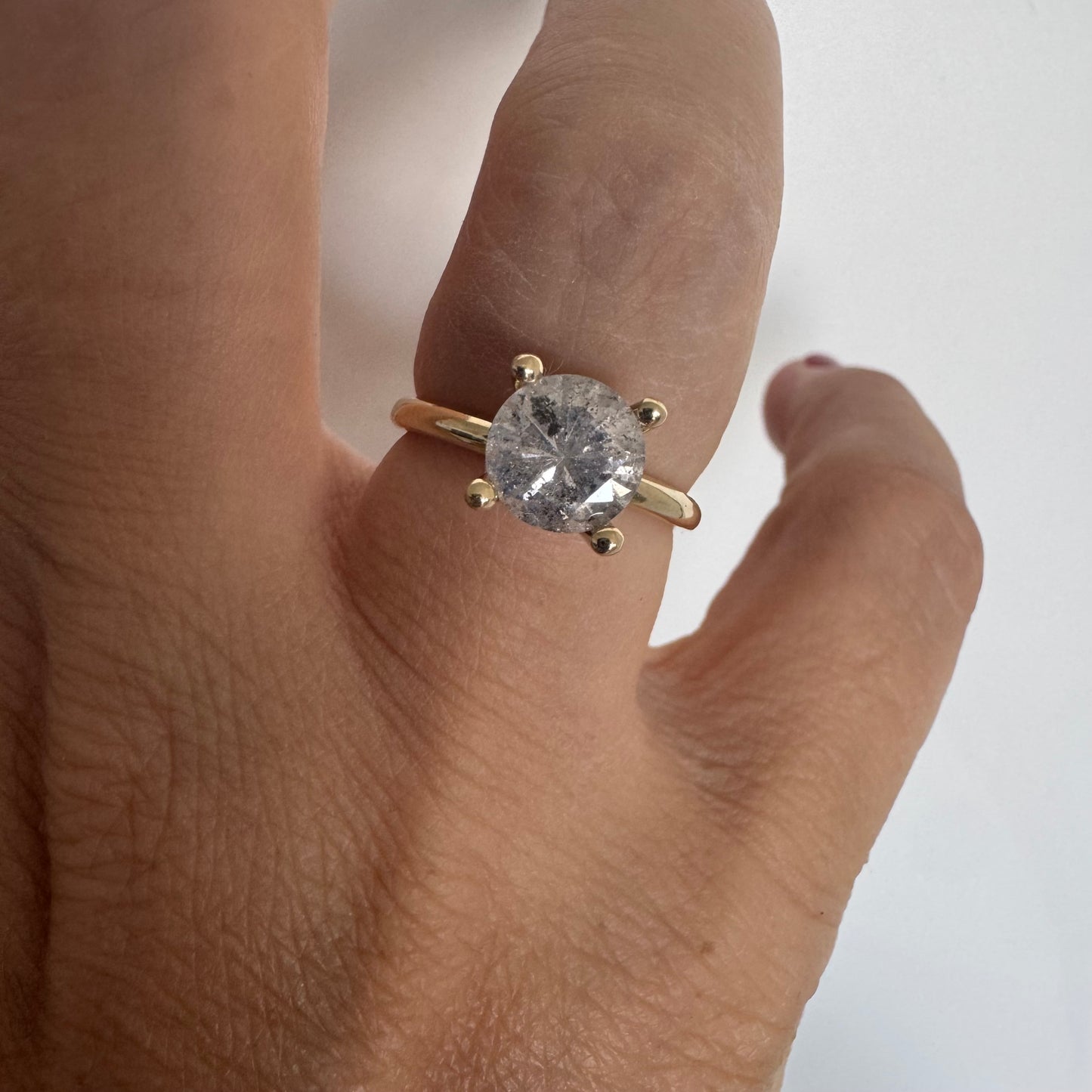 14K gold solitaire ring set with a central round Diamond