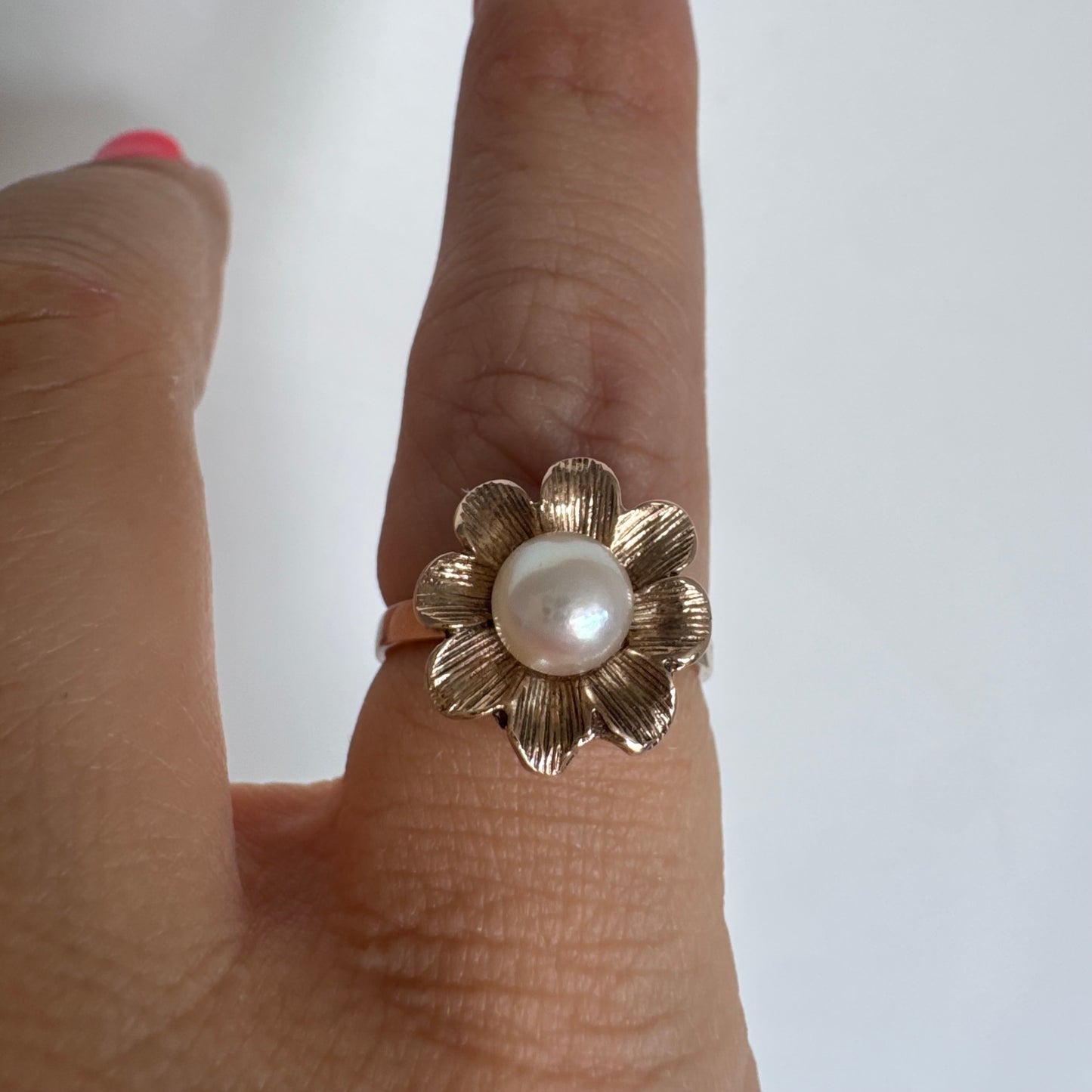 9K gold flower ring set with a lustrous Pearl at the center.