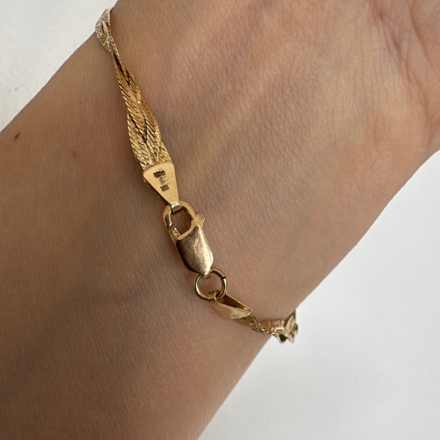 צמיד זהב צהוב 10 קראט בעיצוב קלוע עם טקסטורה עדינה שמחזירה אור וברק רך.