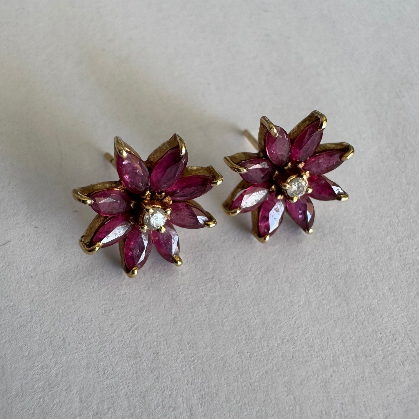 14K gold floral earrings set with marquise-cut Rubies and a small Diamond at the center