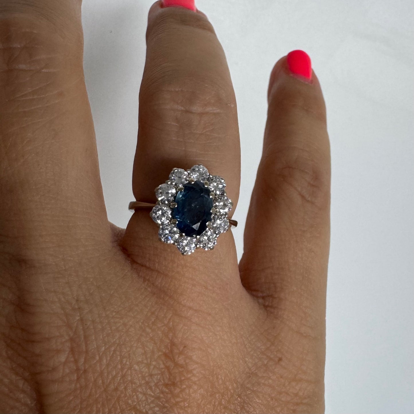 18K gold ring featuring a deep blue Sapphire at its center, surrounded by a sparkling halo of Diamonds