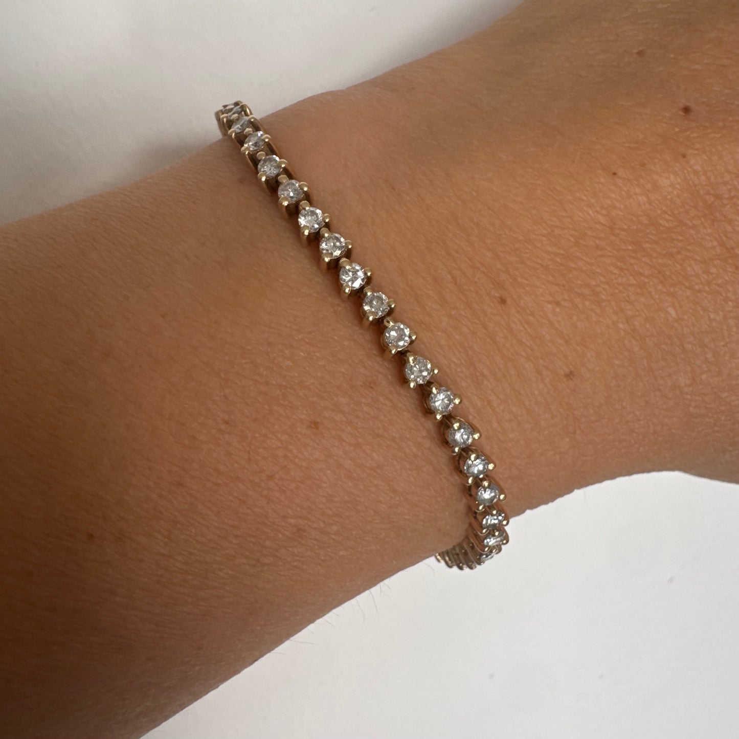 14K gold tennis bracelet set with a continuous line of round Diamonds, creating a delicate and elegant sparkle.