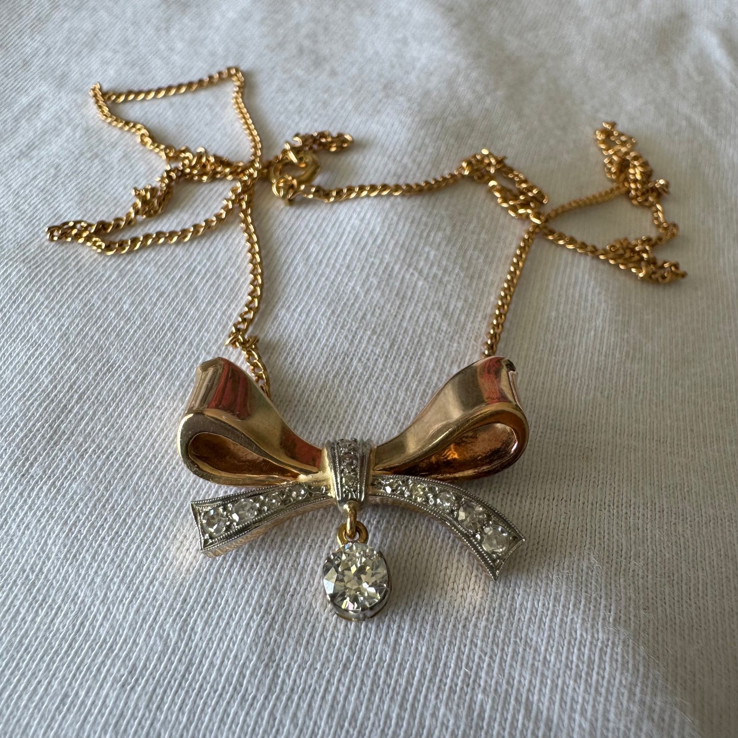 שרשרת זהב 18 קראט עם תליון בצורת סרט קלאסי משובץ יהלומים ונושא יהלום מרכזי תלוי שמוסיף נגיעה של זוהר ואלגנטיות