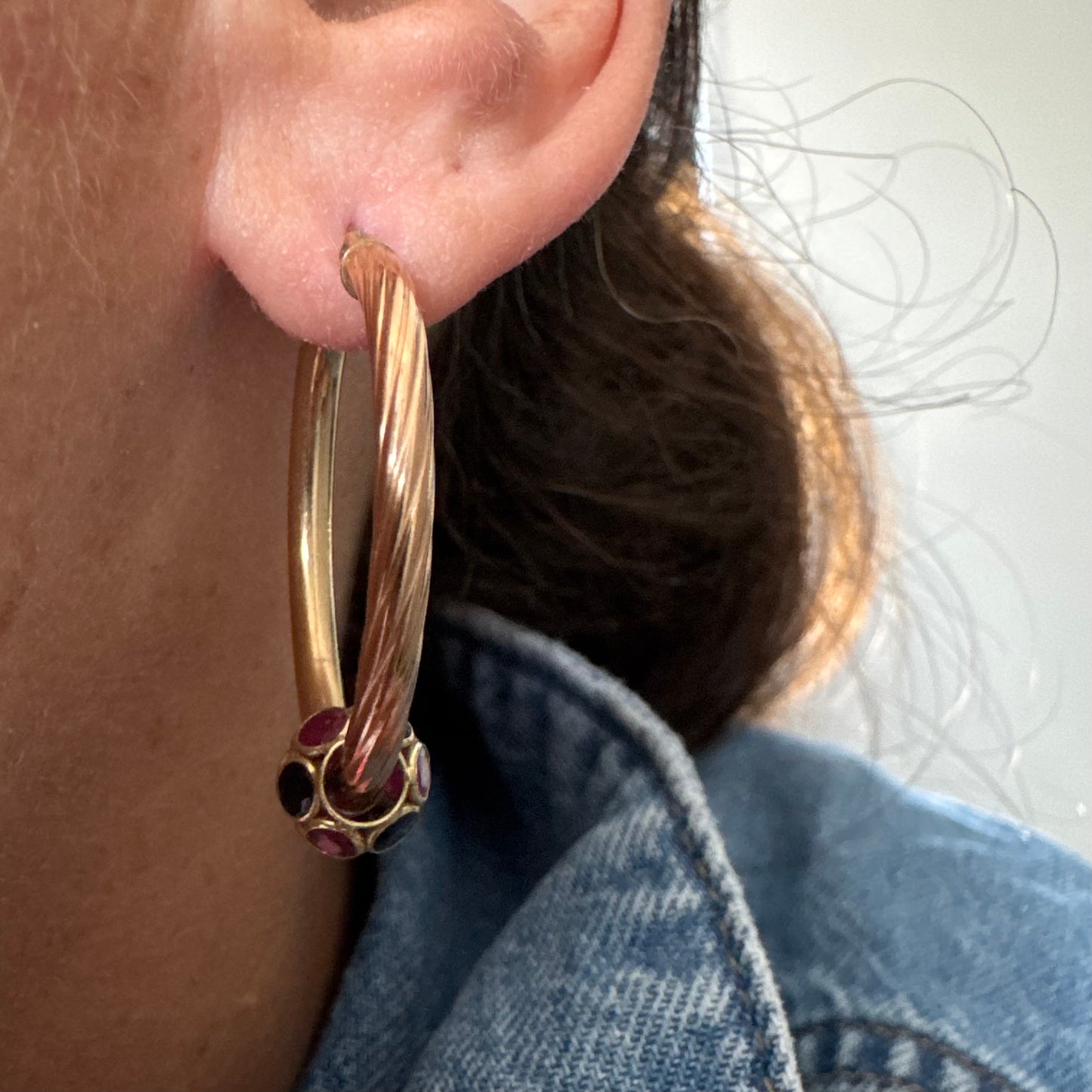 10K gold hoop earrings with a twisted design, set with pink and green Tourmaline.