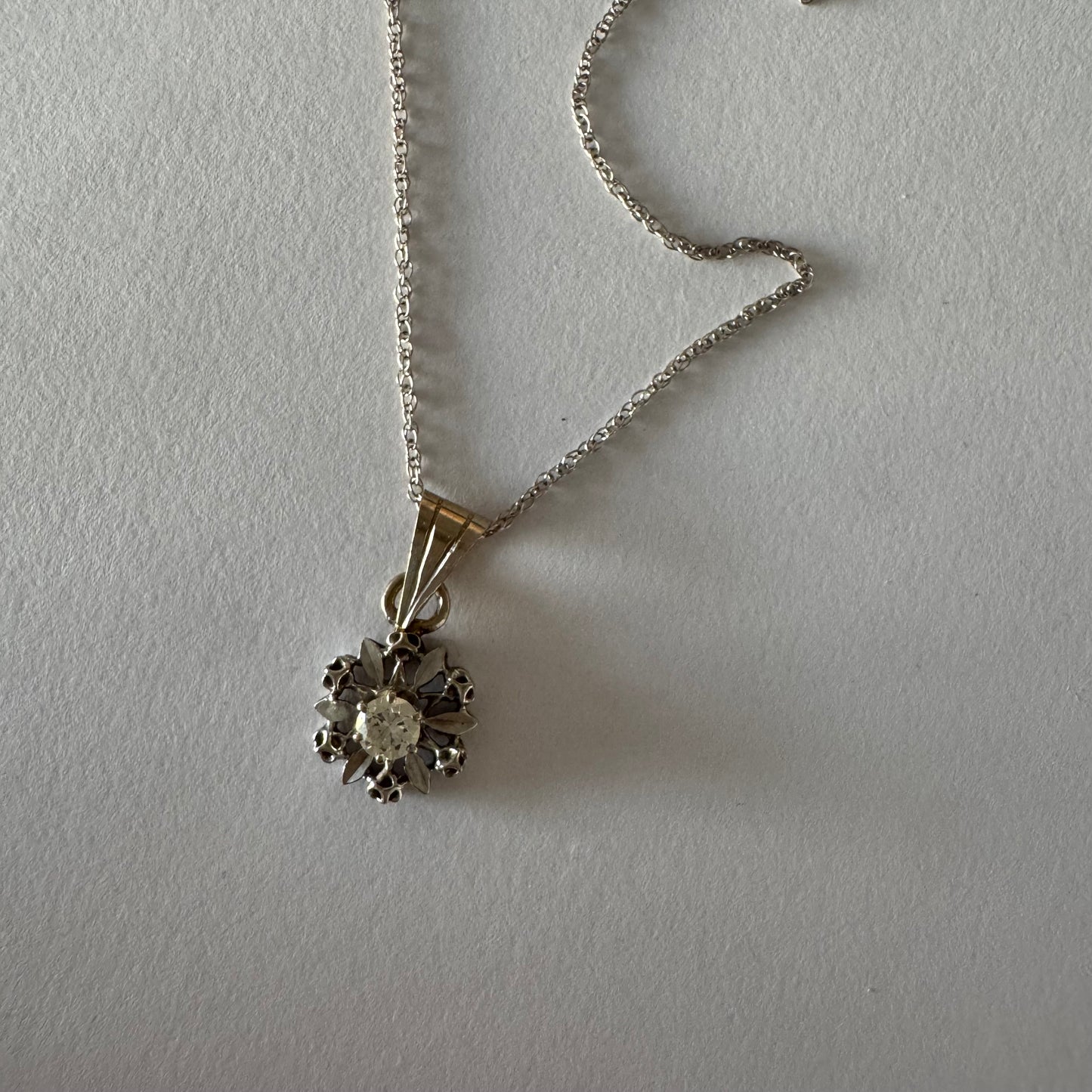 תליון זהב 14 קראט משובץ יהלום מרכזי בעיצוב פרח עדין ומלא נוכחות.