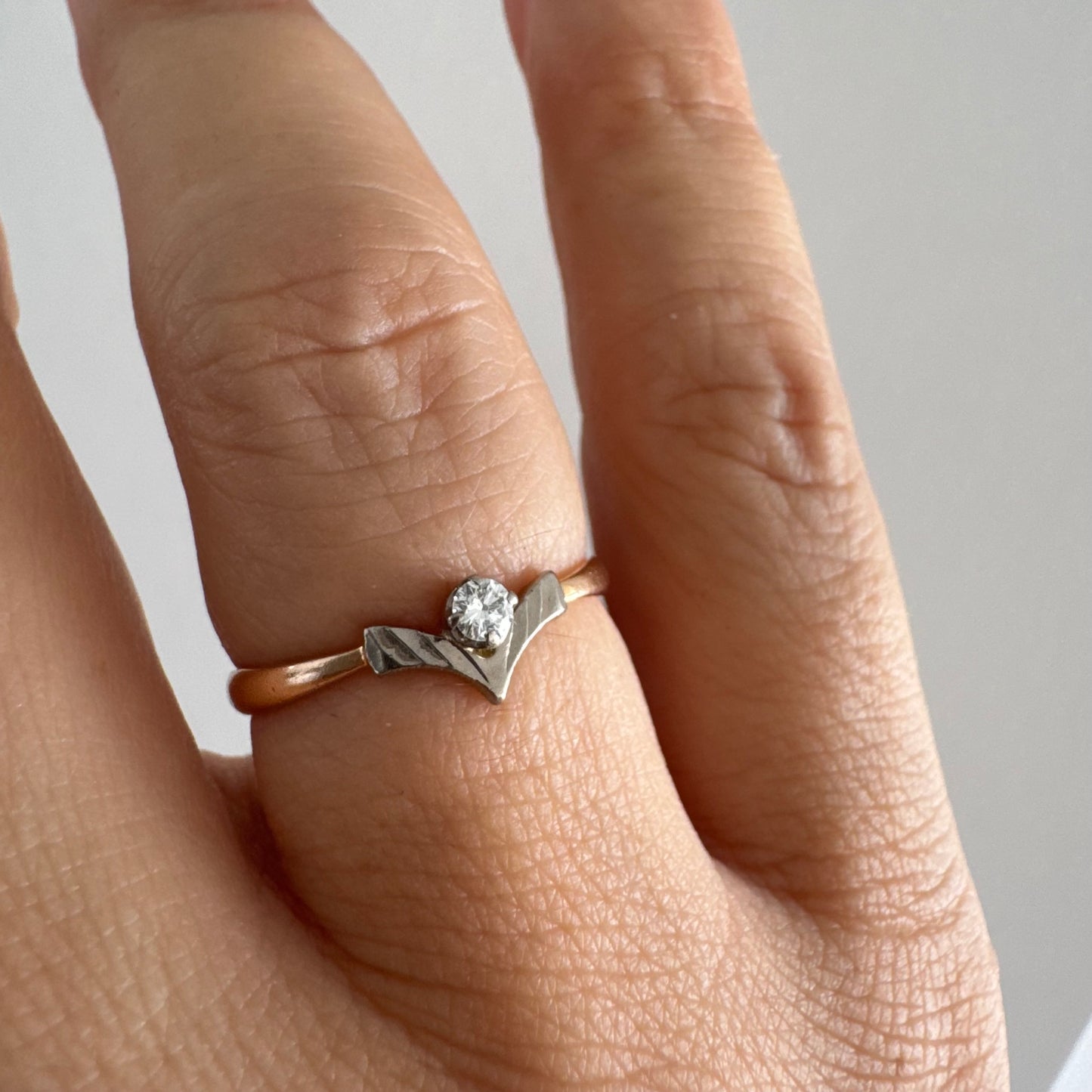 טבעת זהב 14 קראט עם ראש בצורת V מזהב לבן המשובץ יהלום עגול אחד. 