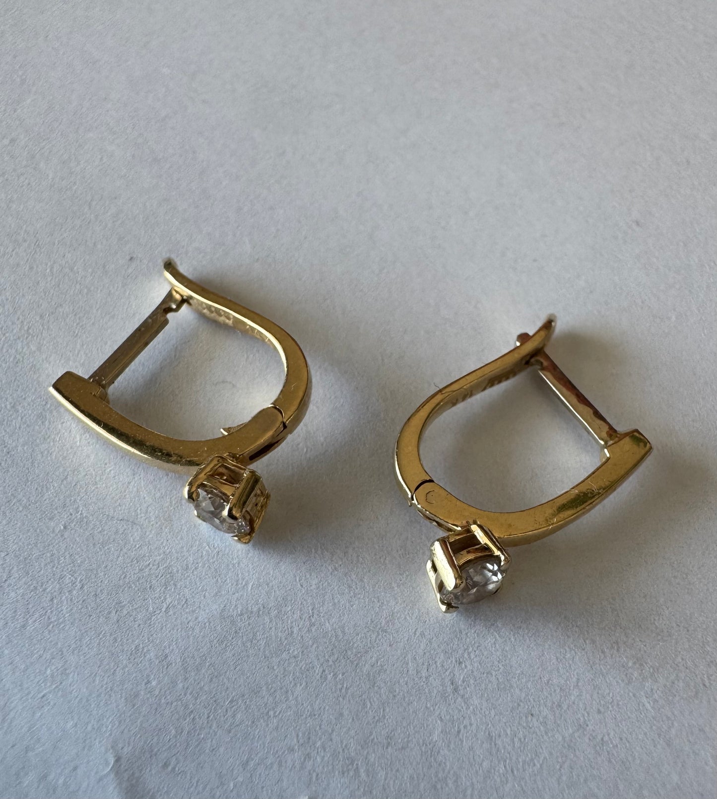 14K gold earrings set with round brilliant-cut Diamonds.
