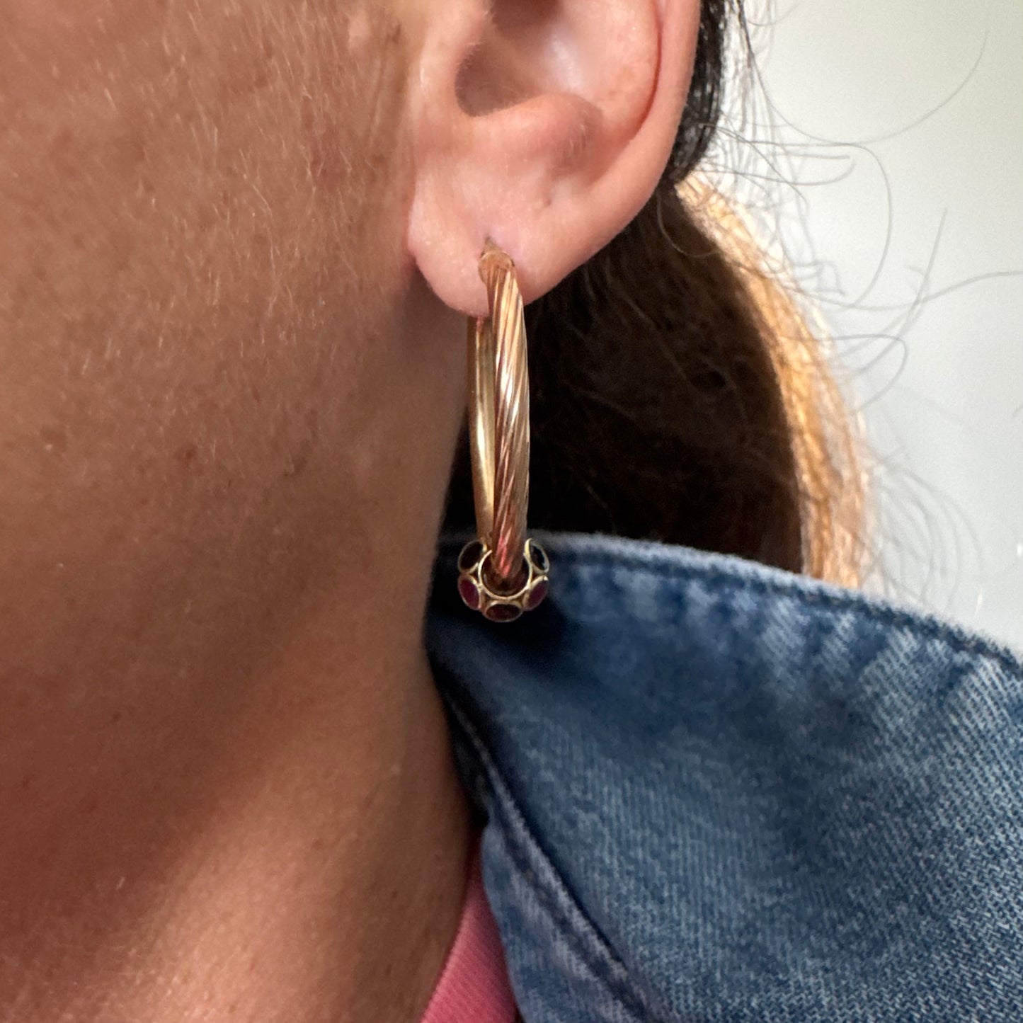 10K gold hoop earrings with a twisted design, set with pink and green Tourmaline.