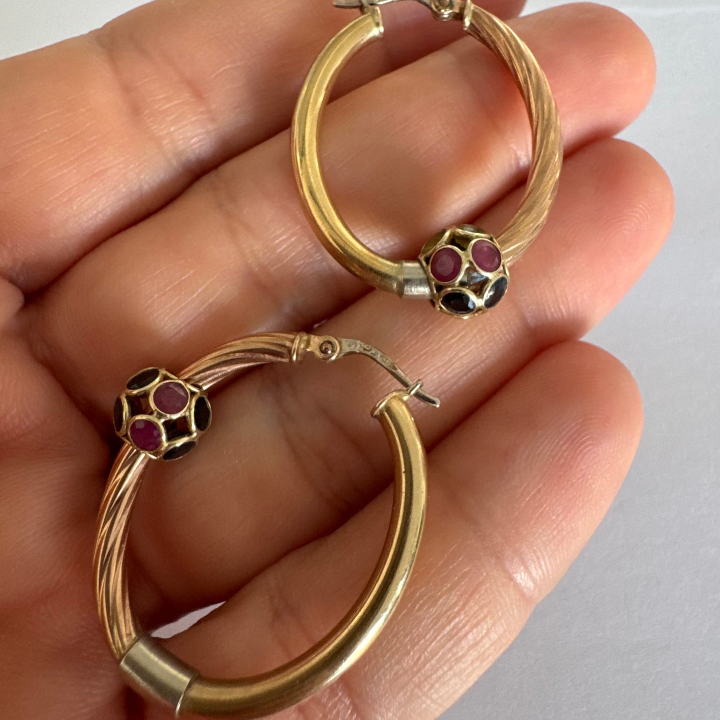 10K gold hoop earrings with a twisted design, set with pink and green Tourmaline.