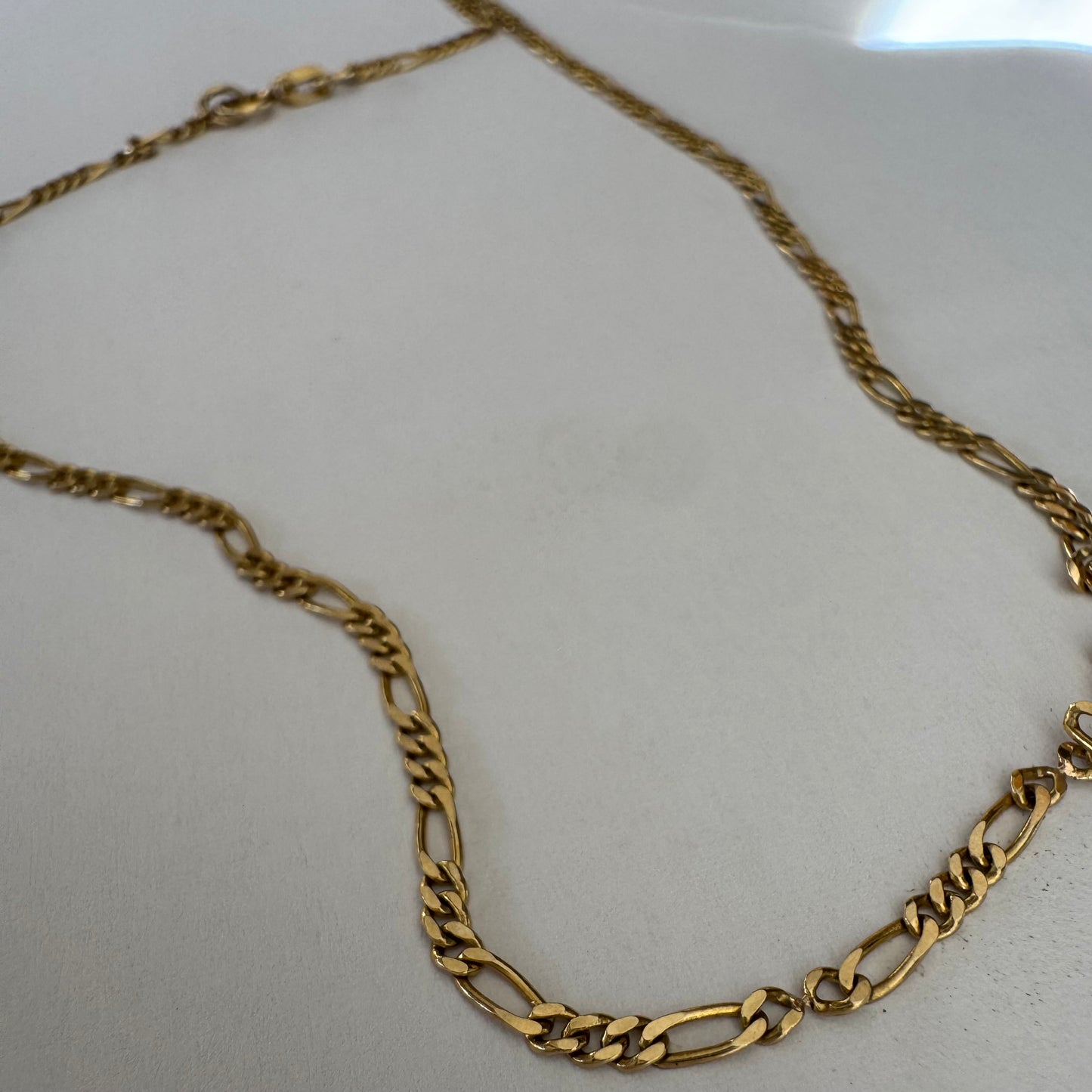 שרשרת זהב צהוב 14 קראט בעיצוב חוליות דקות ומוארכות עם טוויסט עדין שנותן לה מראה אלגנטי ונקי.