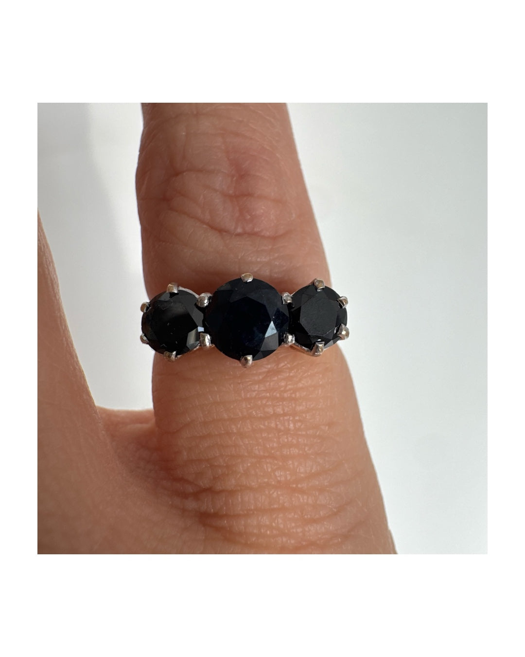 טבעת זהב 10 קראט משובצת שלוש אבני ספיר בצבע כחול כהה בחיתוך עגול, בעיצוב קלאסי עם נוכחות עמוקה ואלגנטית.