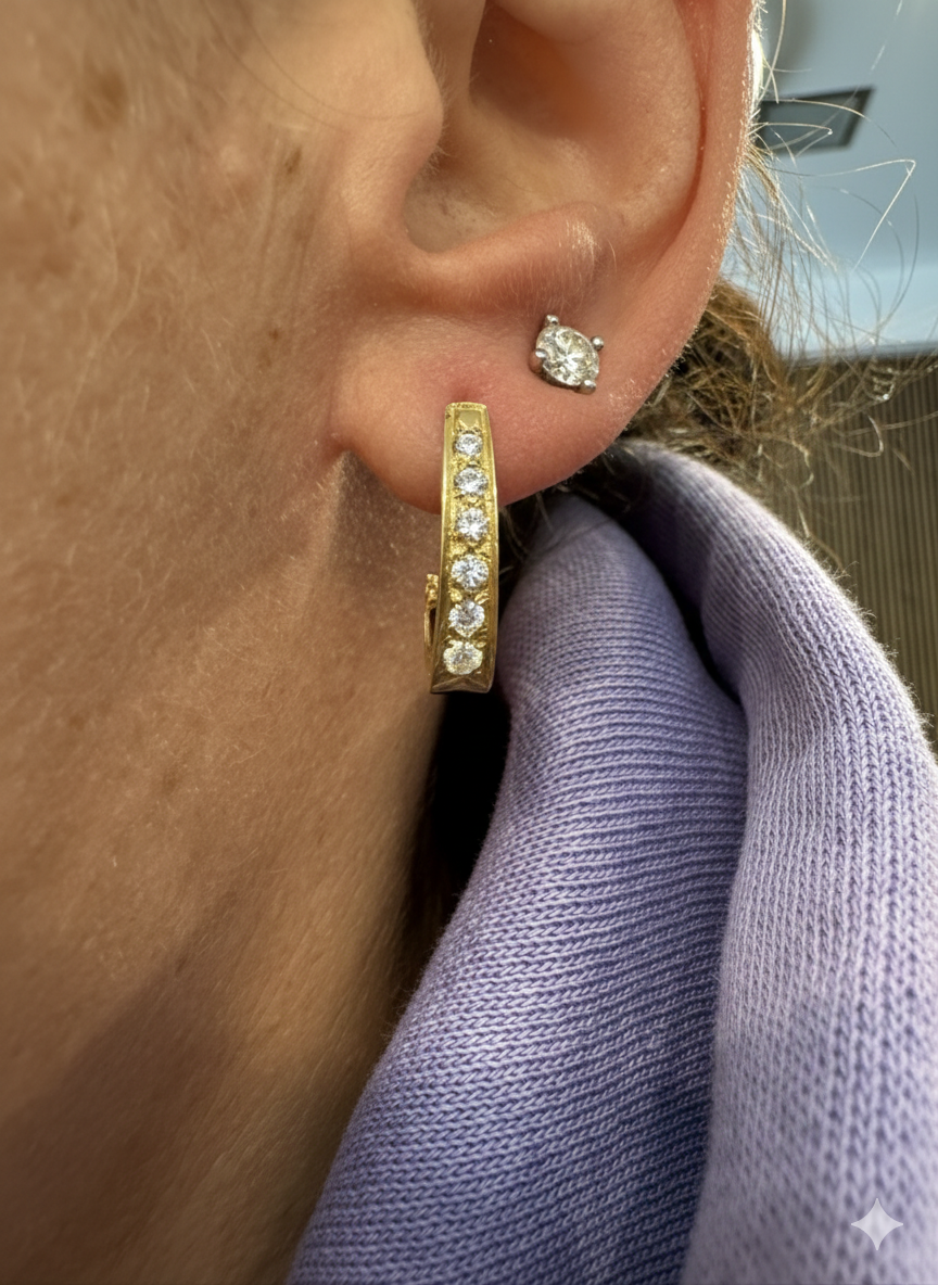 עגיל זהב צהוב 14 קראט בעיצוב אלגנטי ומודרני, משובץ שורת אבני חן שקופות שמעניקות ברק עדין ומדויק.