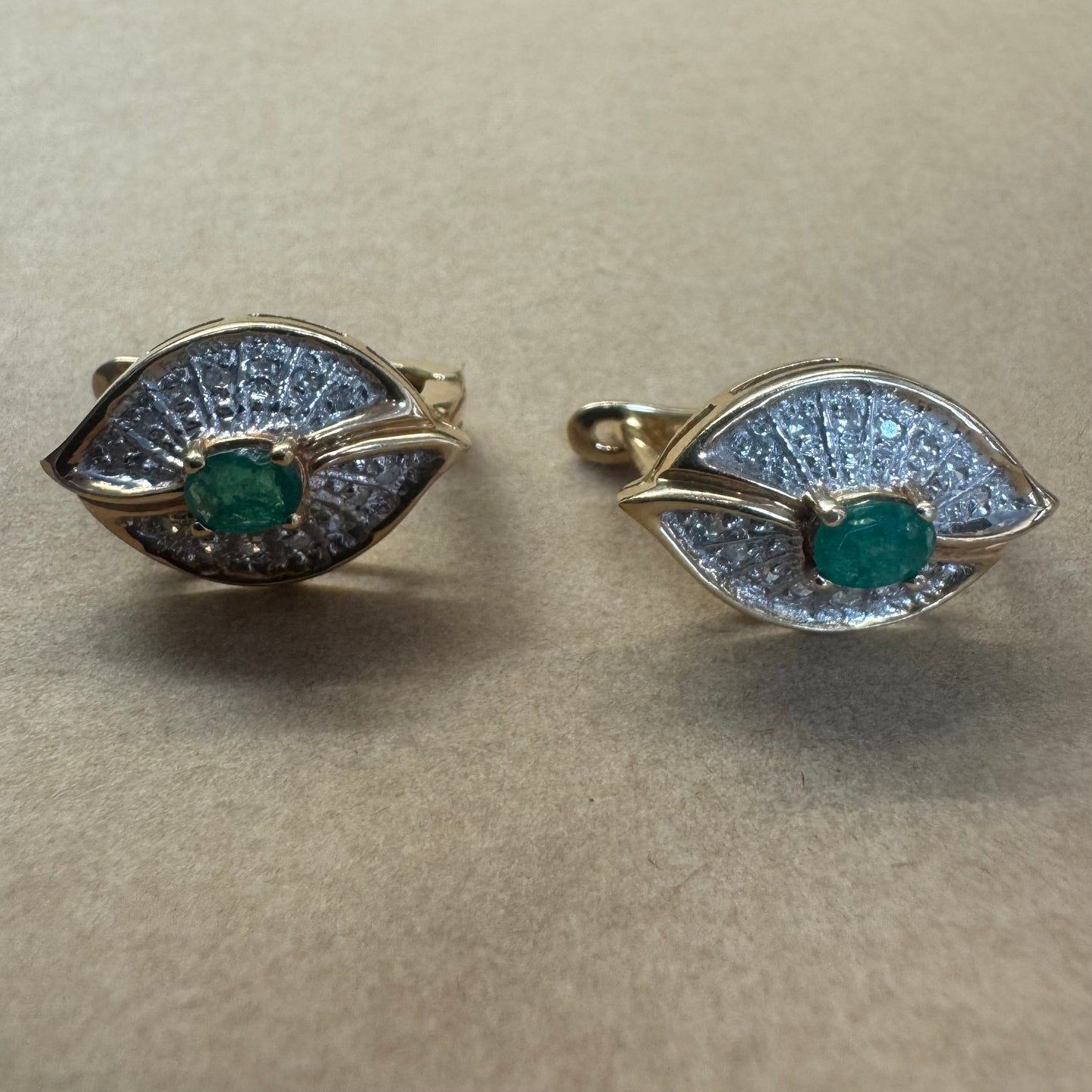14K gold drop earrings in a refined leaf design, set with vivid green Emeralds at the center and shimmering pavé-set Diamonds along the curves
