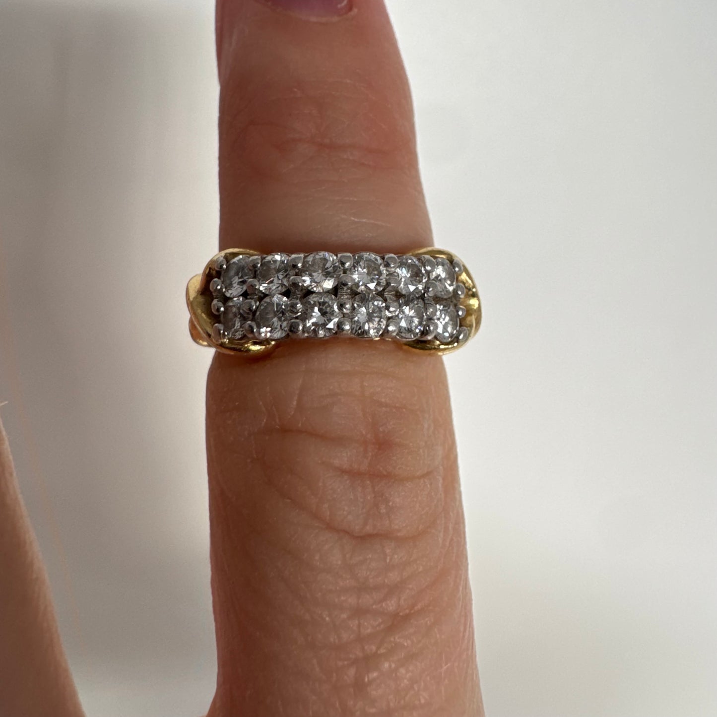 טבעת זהב צהוב 18 קראט משובצת יהלומים עגולים בשתי שורות צפופות, במבנה מלבני מעוגל.