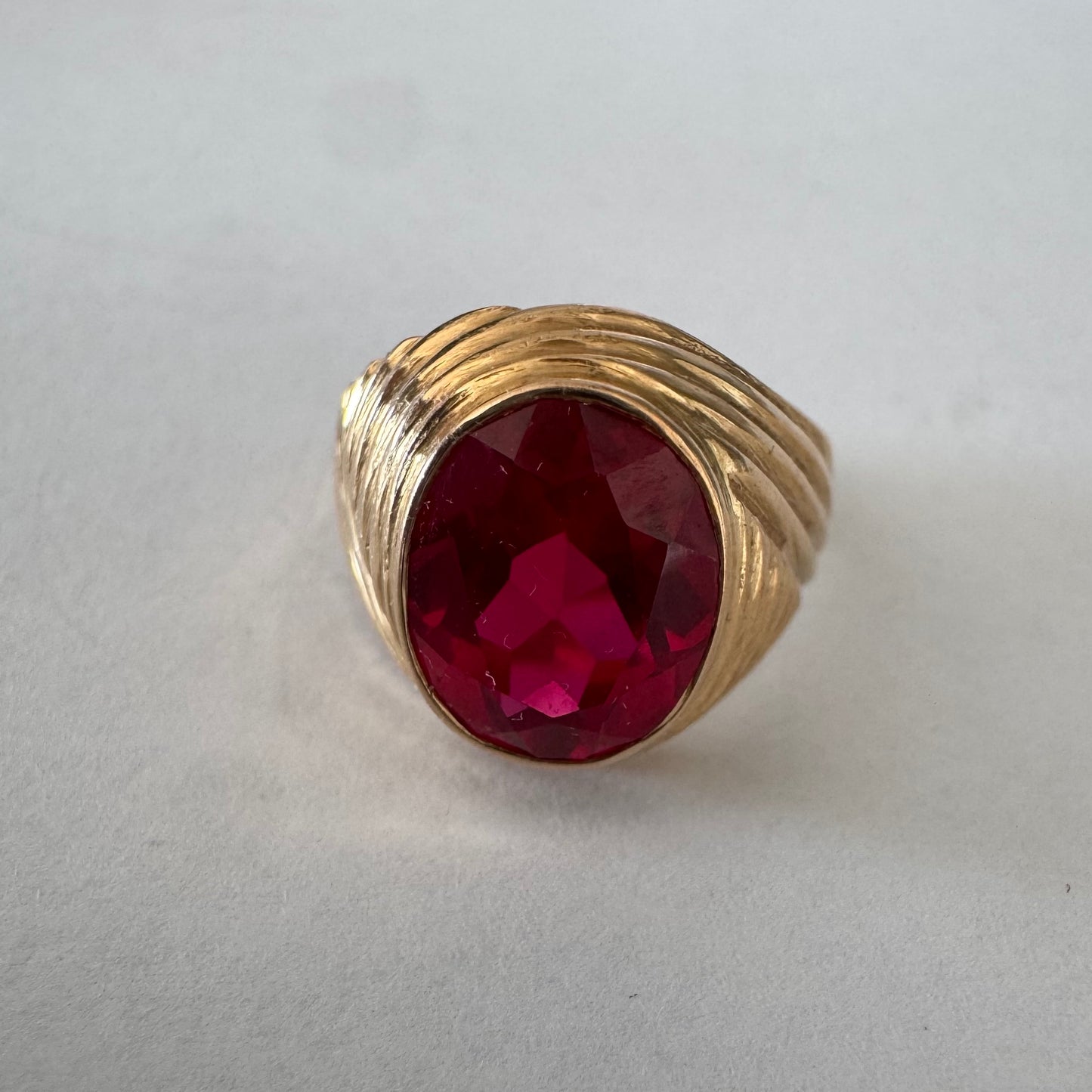 18K gold ring set with a striking oval-cut Ruby gemstone.