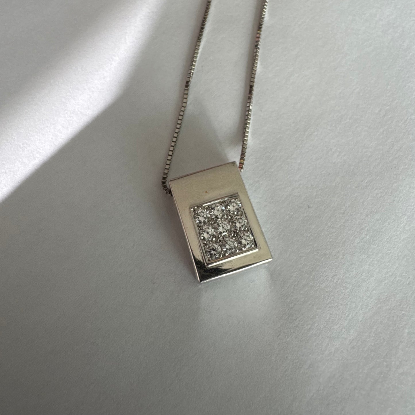 תליון זהב לבן 18 קראט משובץ יהלומים בחיתוך עגול, בשיבוץ צפוף ומדויק היוצר מראה אלגנטי ונקי. 