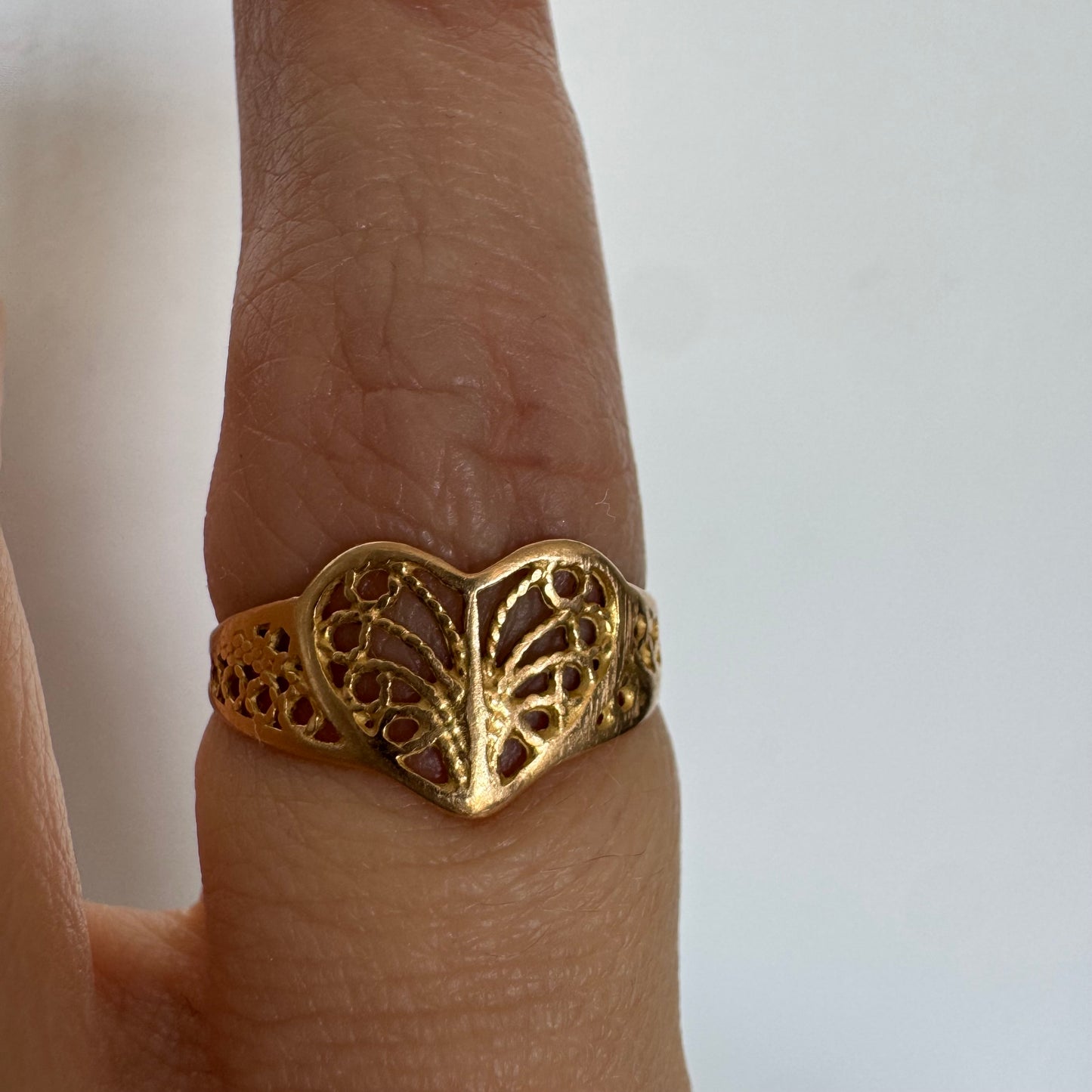 טבעת זהב 21 קראט בעיצוב לב עדין עם עבודת פיליגרן פתוחה.