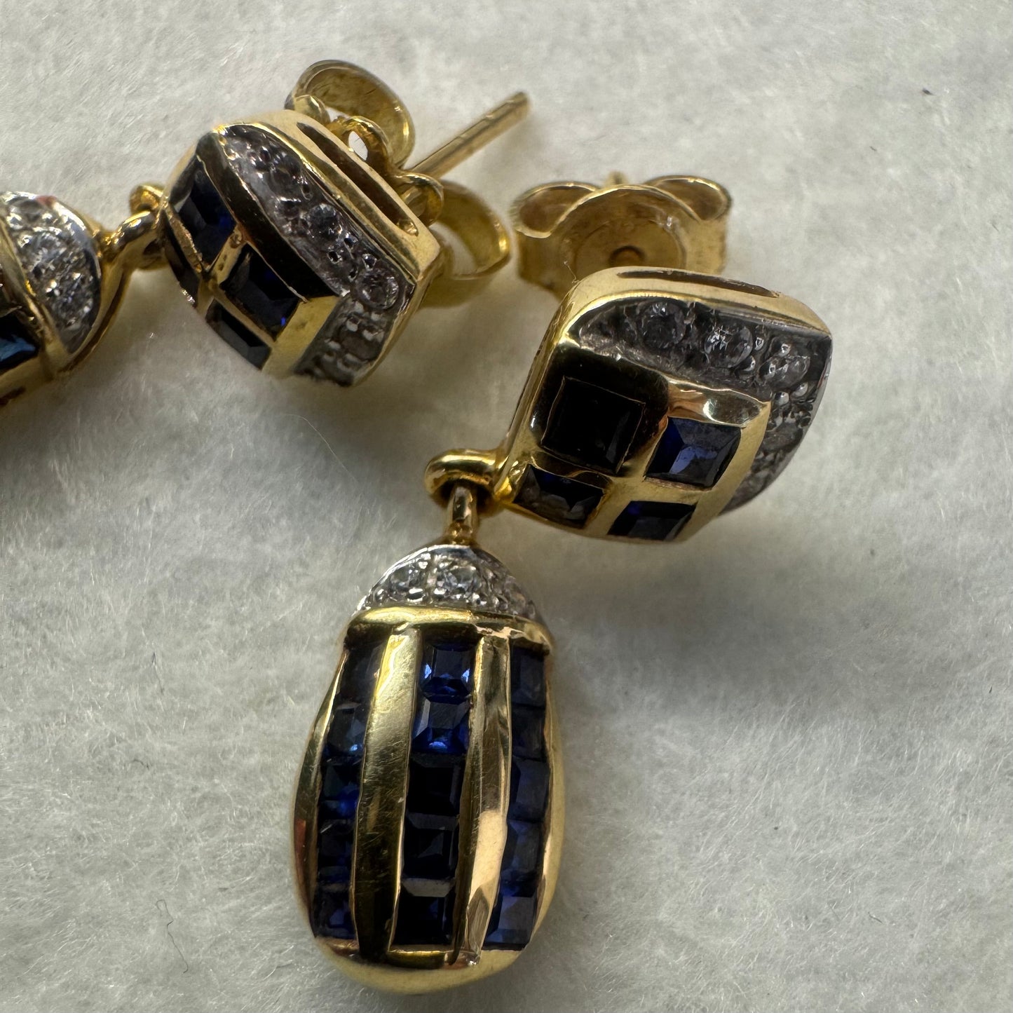 18K old drop earring set with deep blue Sapphires in a geometric pattern, accented with sparkling Diamonds.