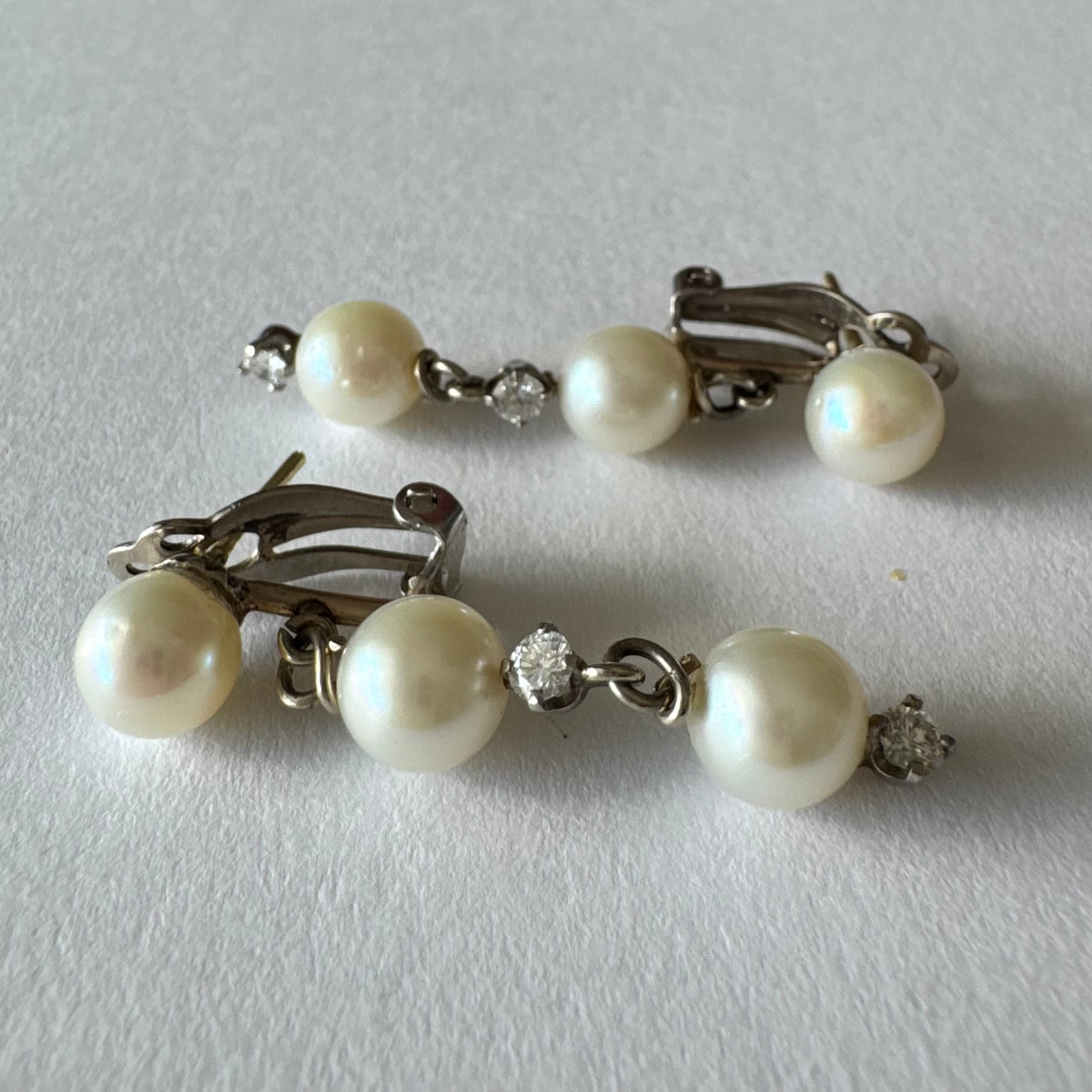 14K gold elegant drop earring set with three soft creamy Pearls connected by round brilliant Diamonds